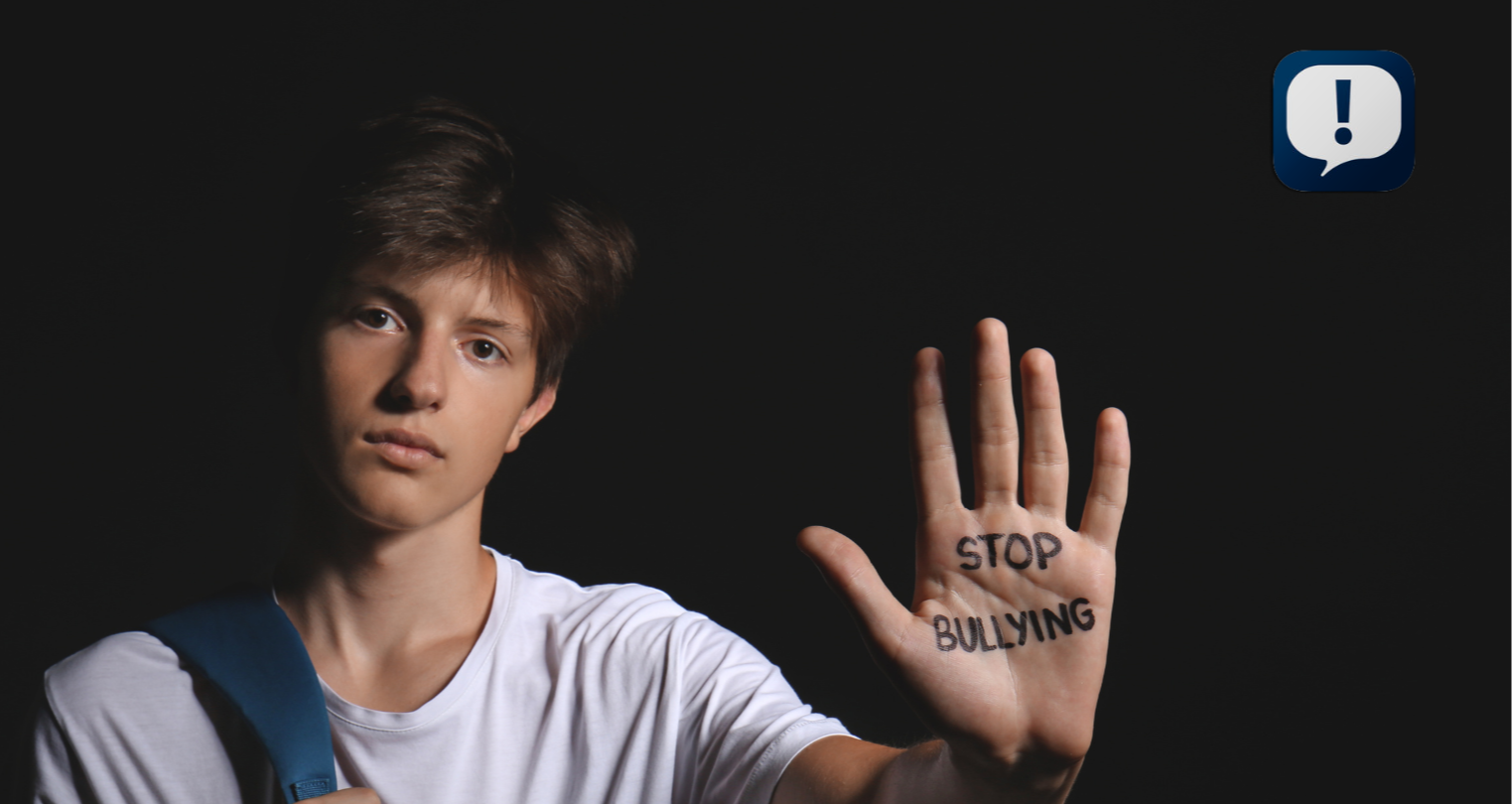 boy holding up his hand and on his palm it says "Stop Bullying"