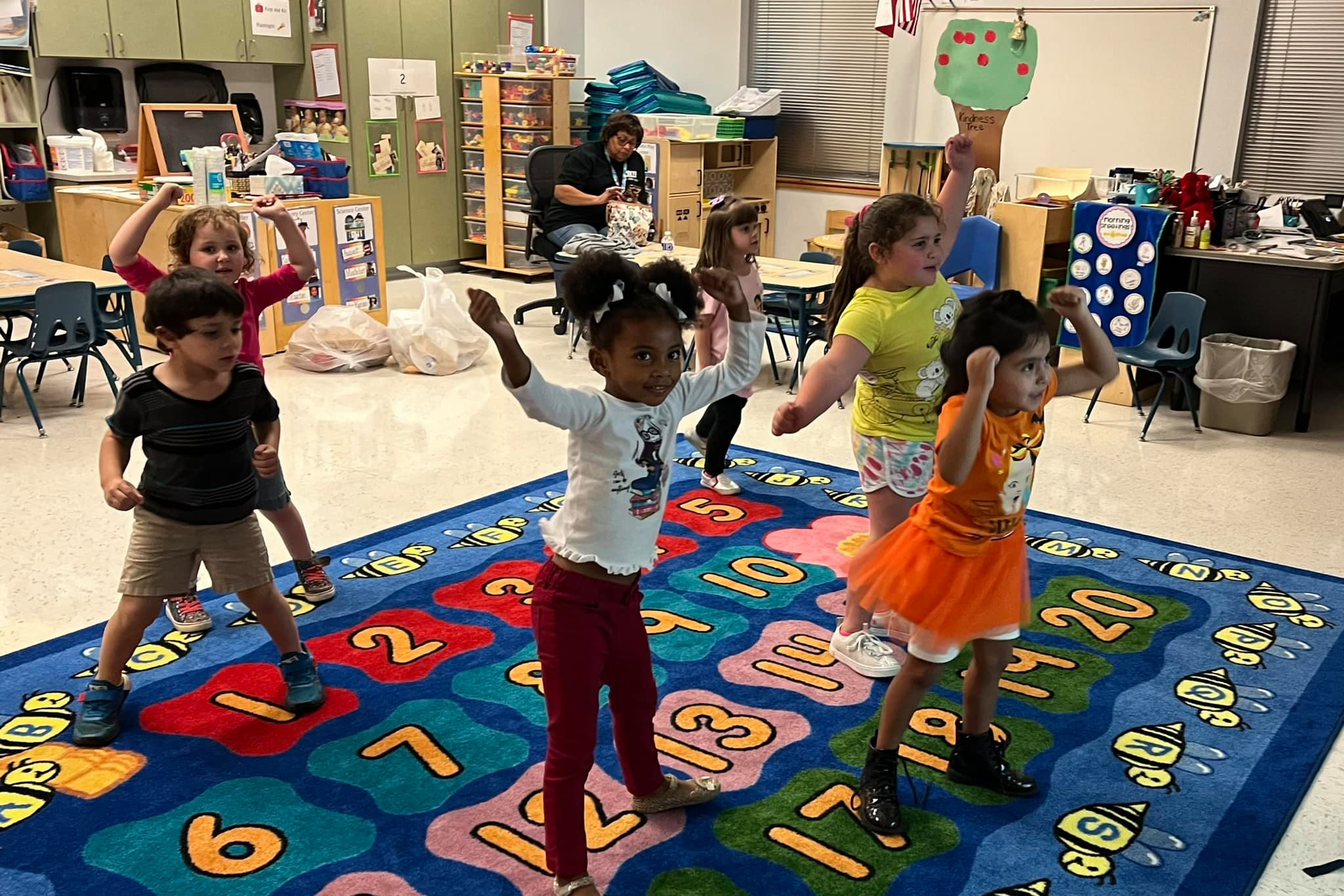 prek kids jumping on a rug in classroom