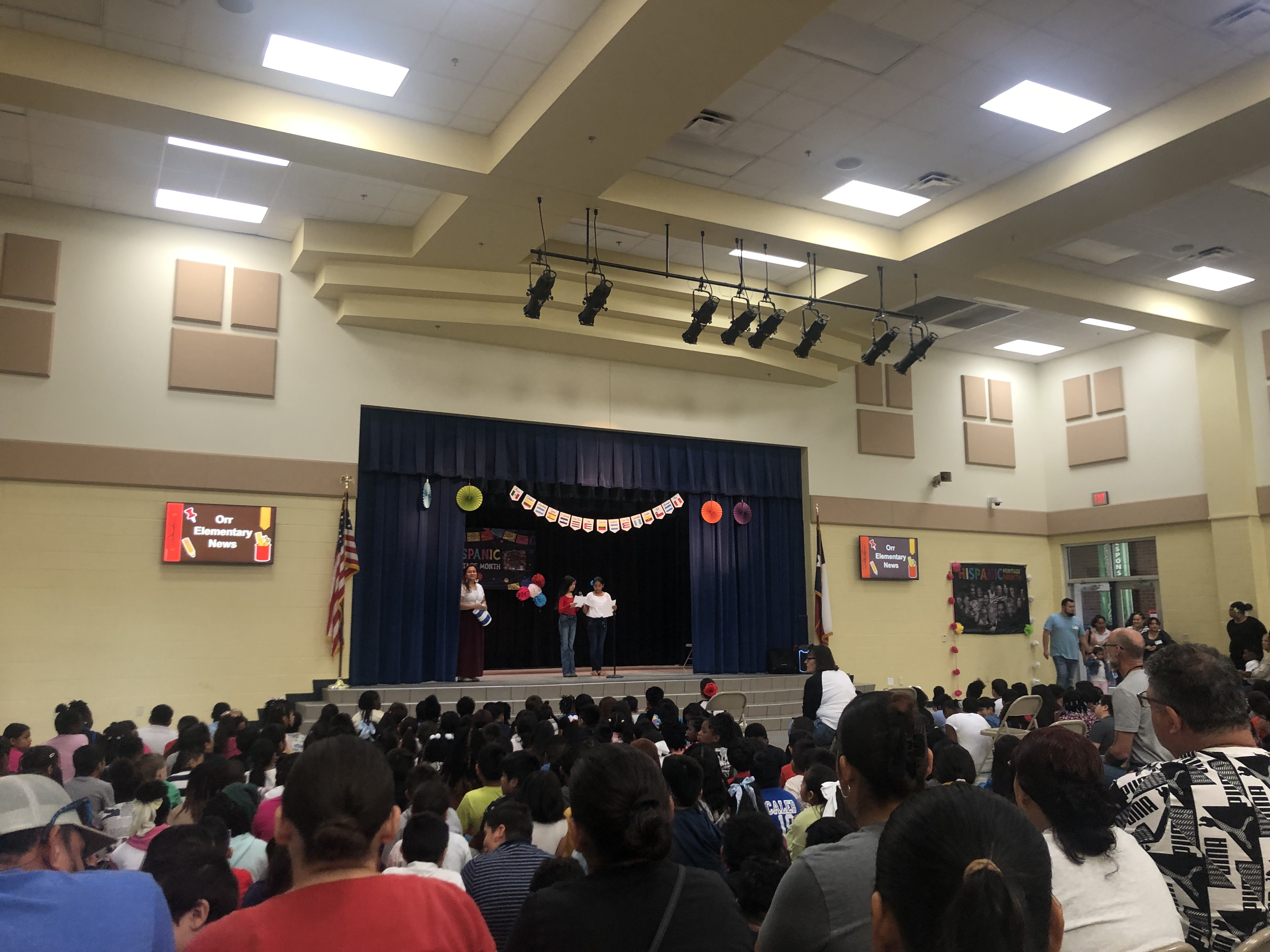 room full of people watching a performance on stage