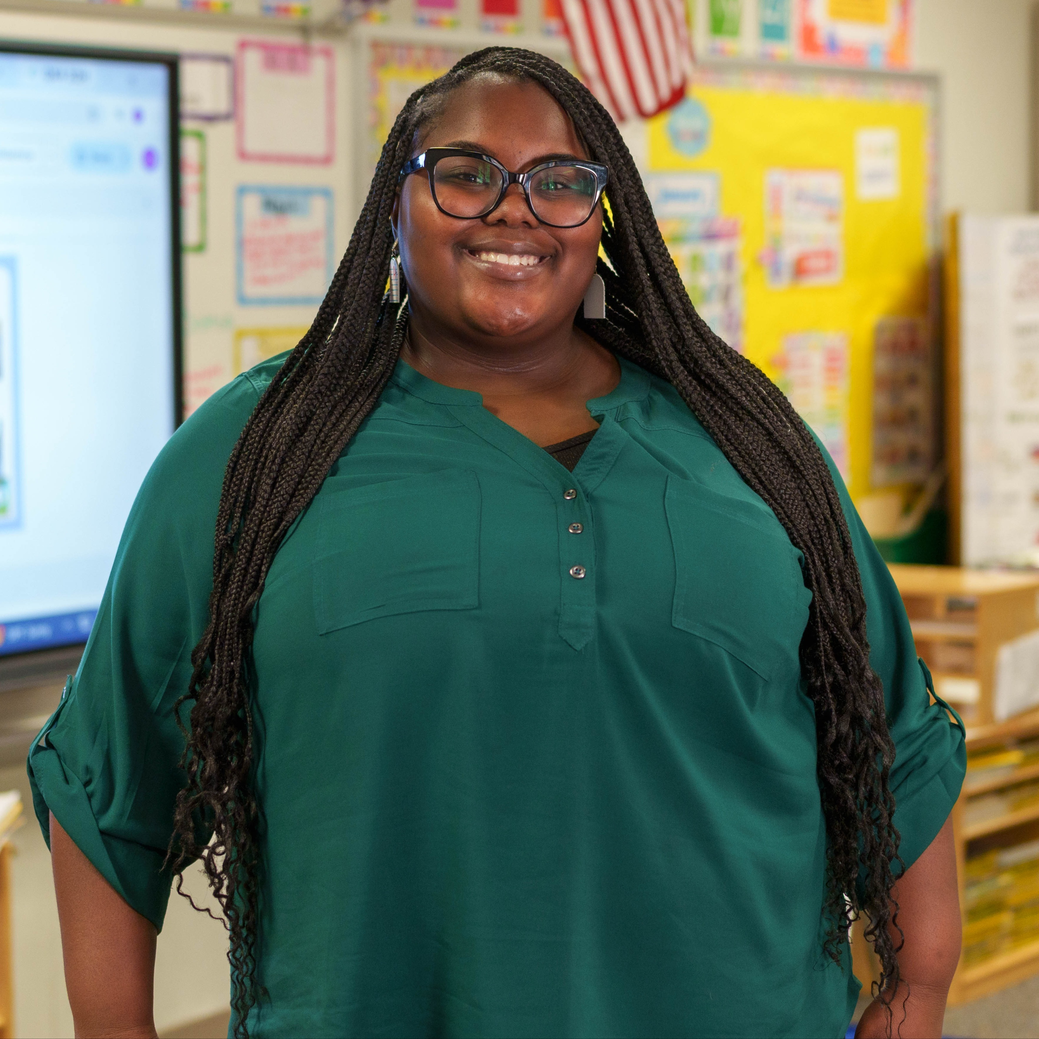 African American woman wearing green shirt standing in classroom