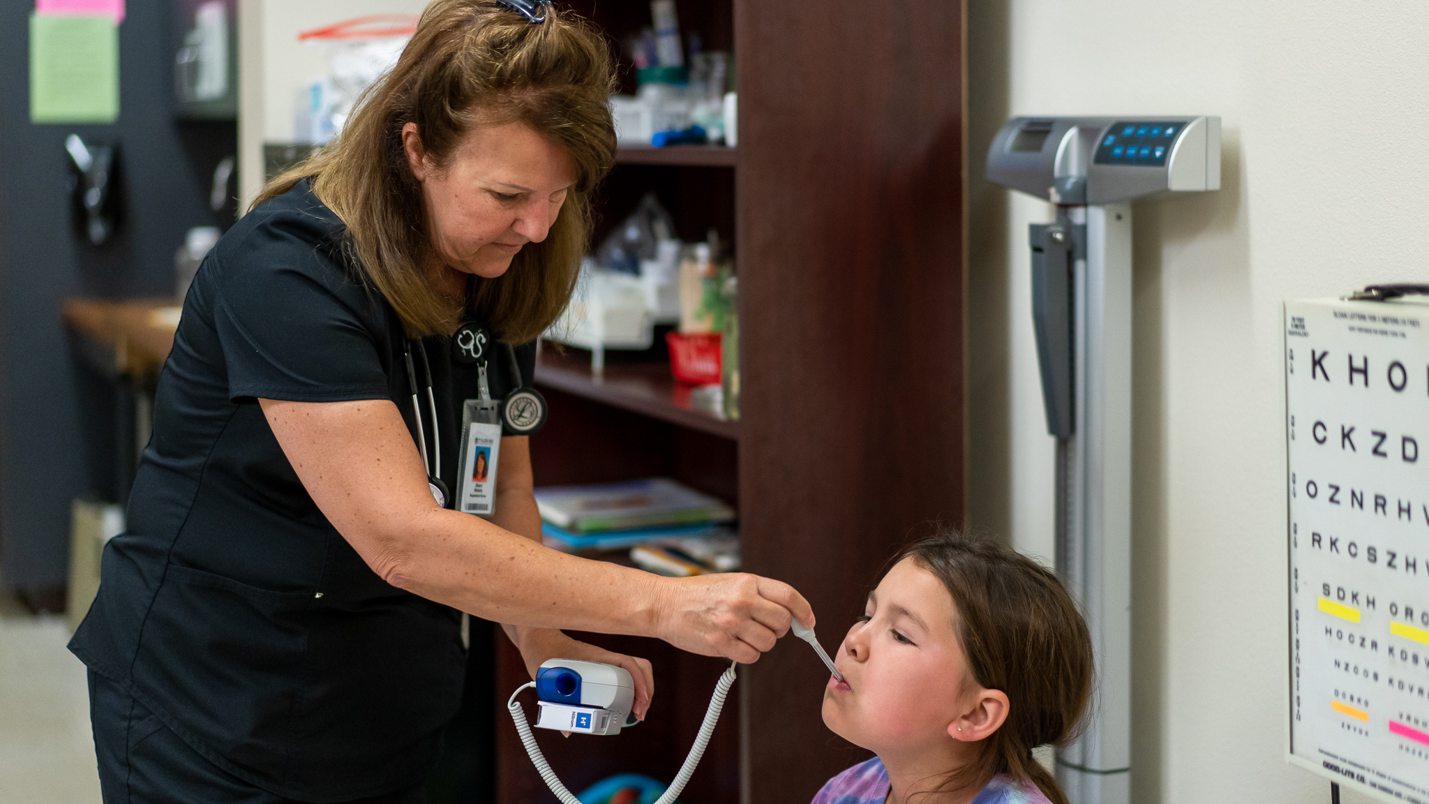nurse taking young girls temperature