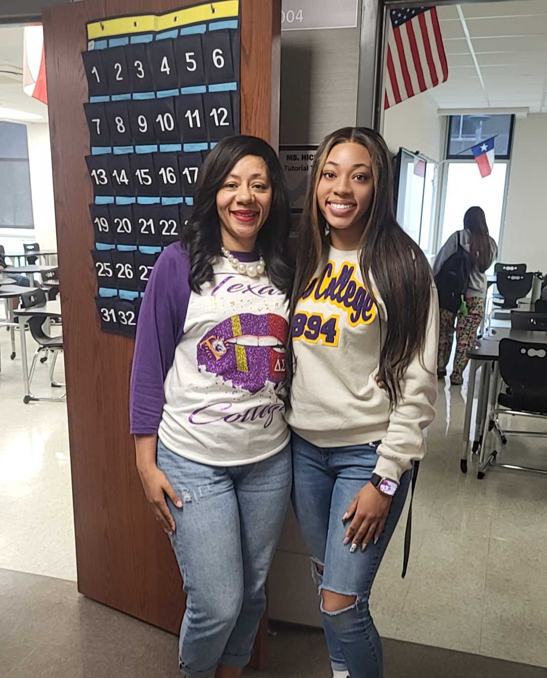 two women standing next to each other in hallway