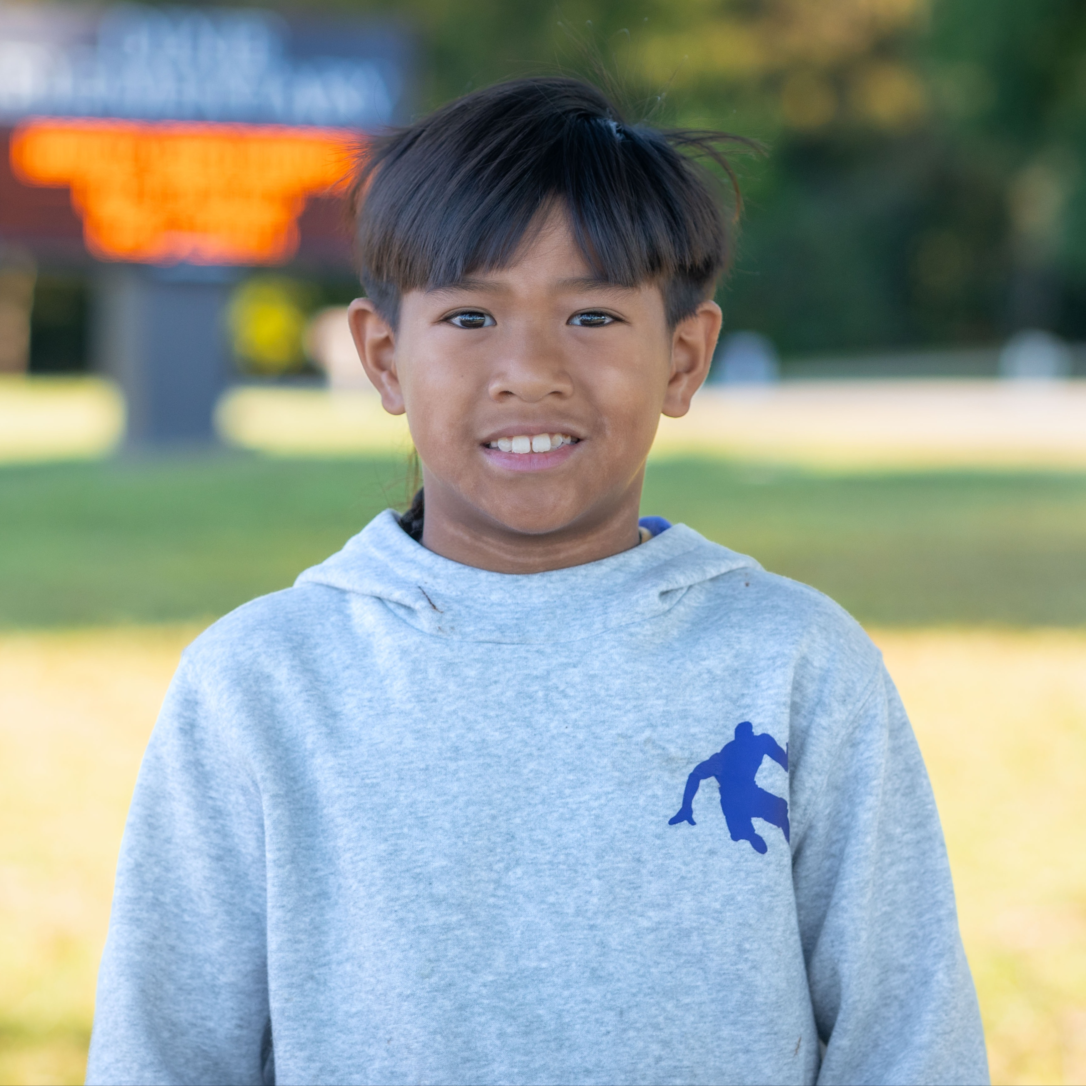 elementary age Hispanic boy wearing gray sweatshirt