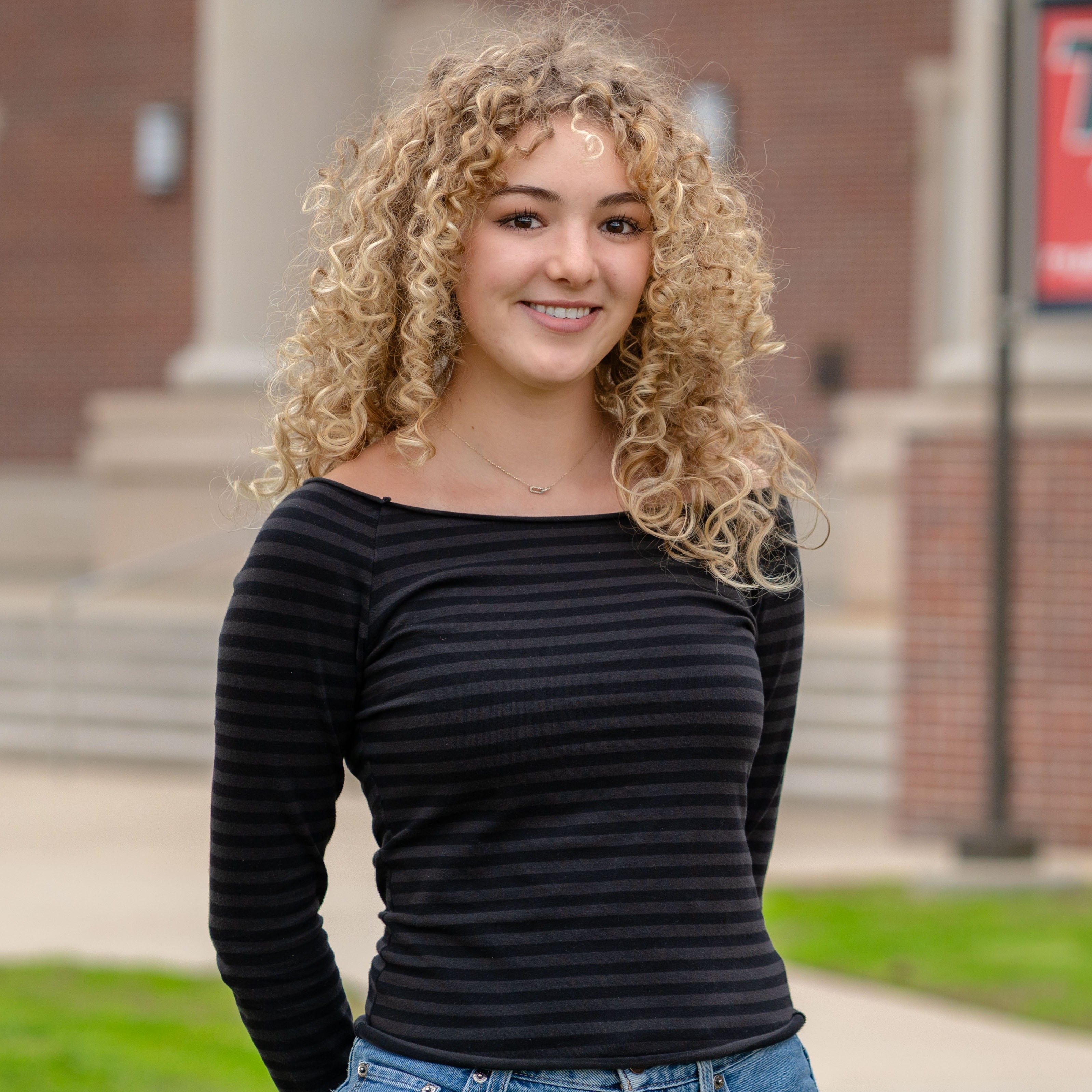 teen girl with blonde curly hair smiling