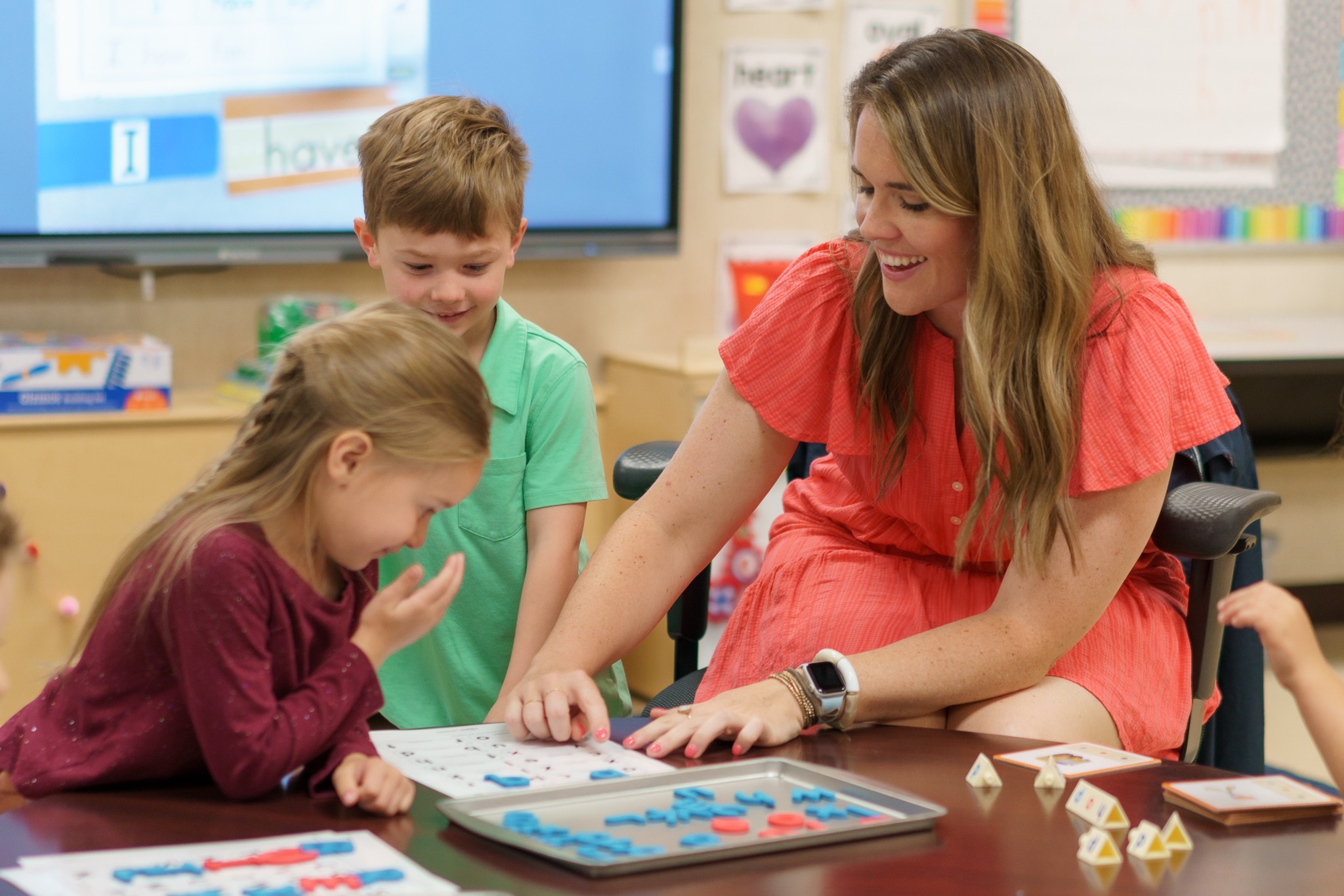 woman and two young kids working on project at table