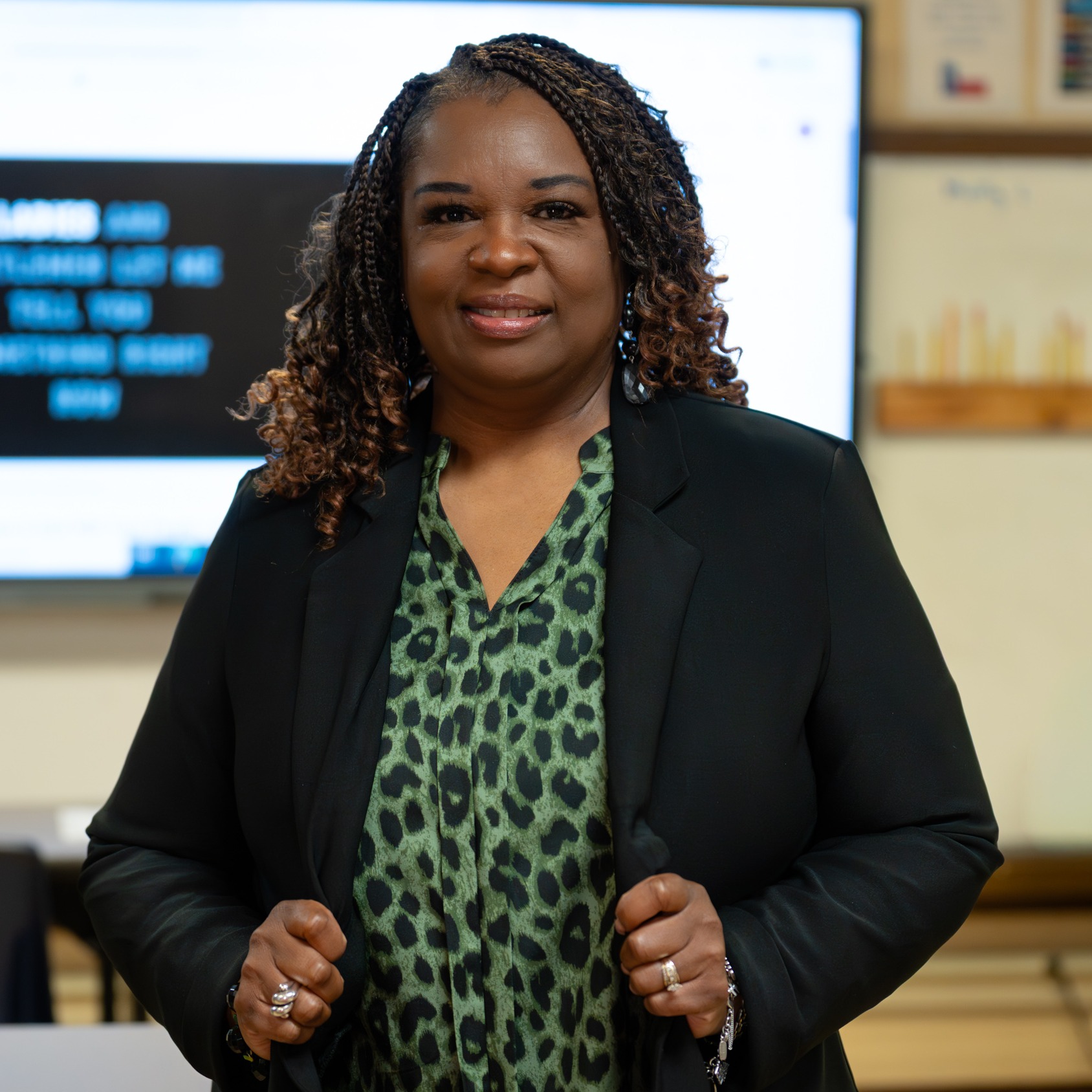 African American woman wearing a green blouse and black jacket