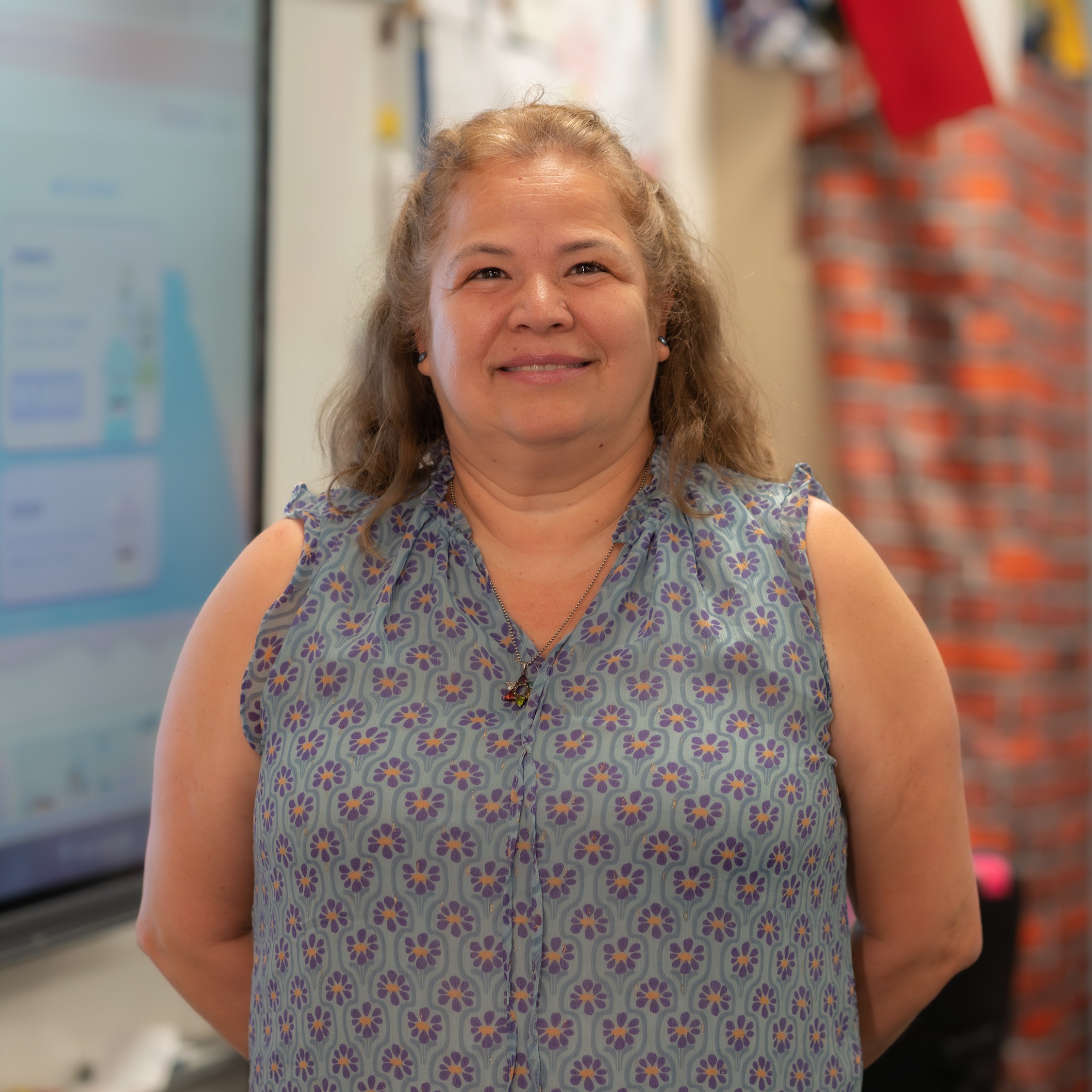 woman with shoulder length hair standing in her classroom