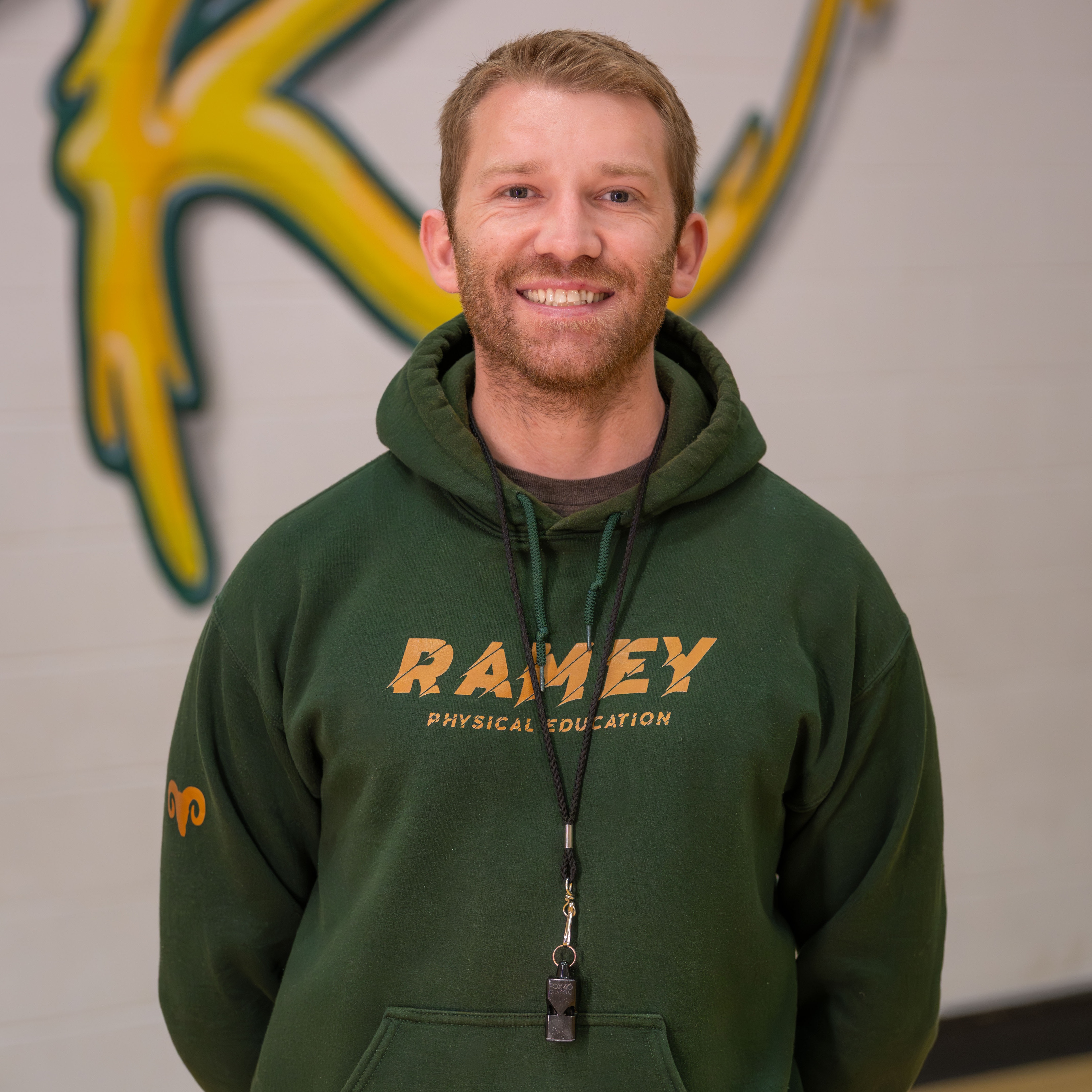 man with beard wearing green hoodie that says, "Ramey Elementary School."