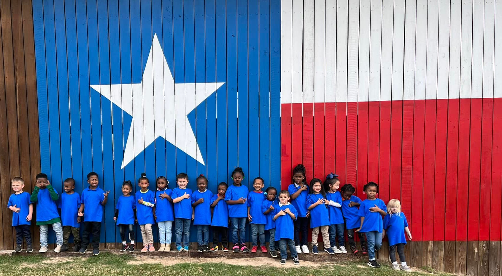 students standing by texas flag barn
