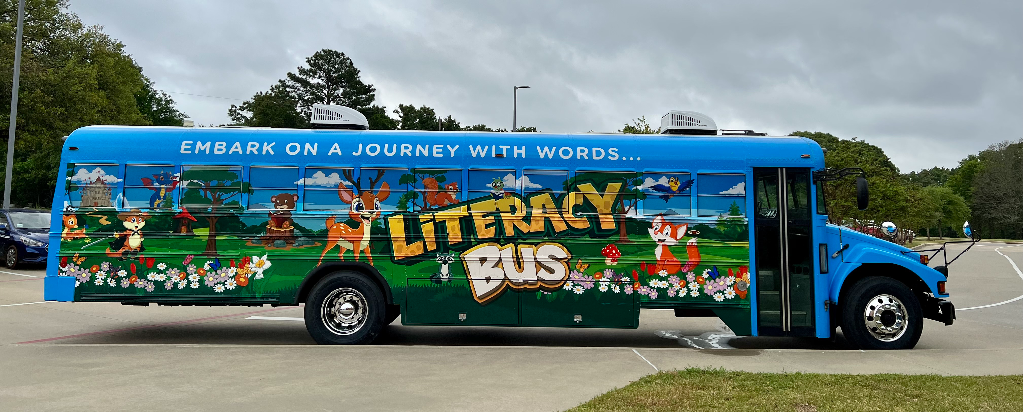 embark on a journey with words...Literacy Bus - school bus painted blue with flowers, deer, bear, fox, birds, trees, grass