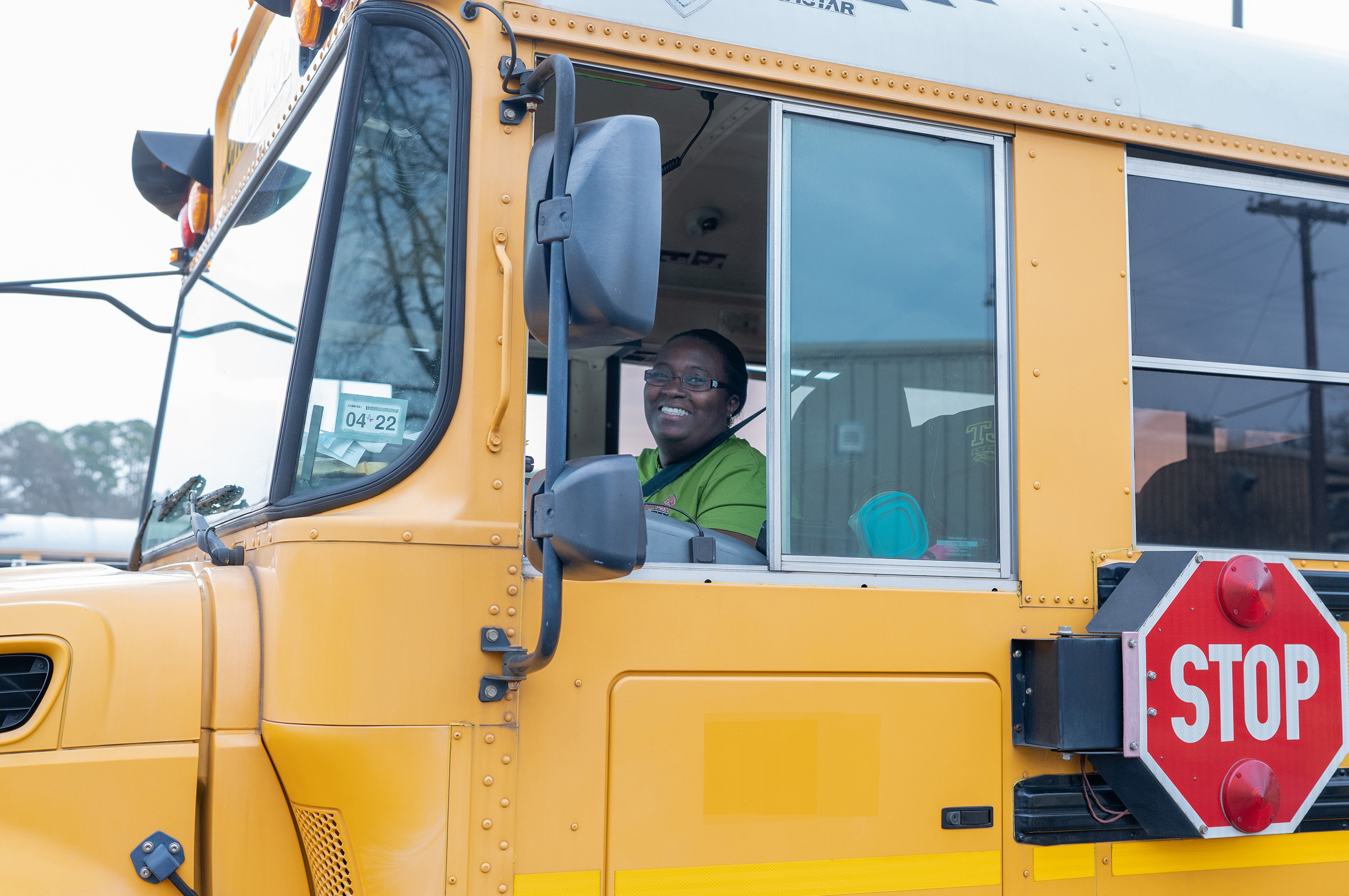 African American female sitting at the wheel of a school bus