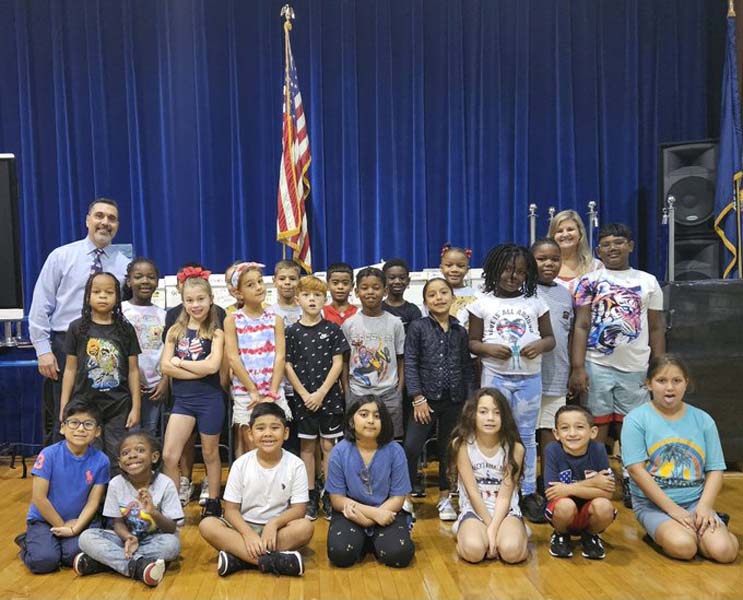To commemorate 9/11, students at Belmont Elementary in front of the remembrance flag. Students and staff at DeLuca Elementary also participated in a 9/11 remembrance ceremony.