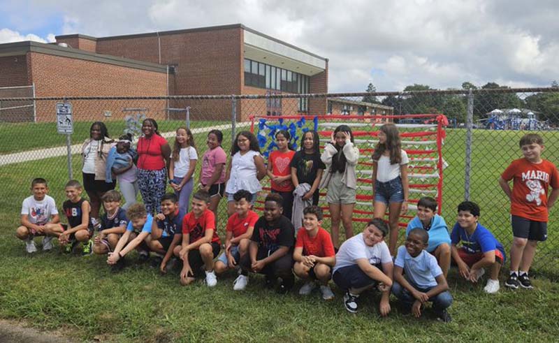 To commemorate 9/11, students at Belmont Elementary in front of the remembrance flag. Students and staff at DeLuca Elementary also participated in a 9/11 remembrance ceremony.