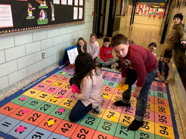 Mrs. Kresic's fourth-grade class finding factors of numbers and least common multiples on our new mats!