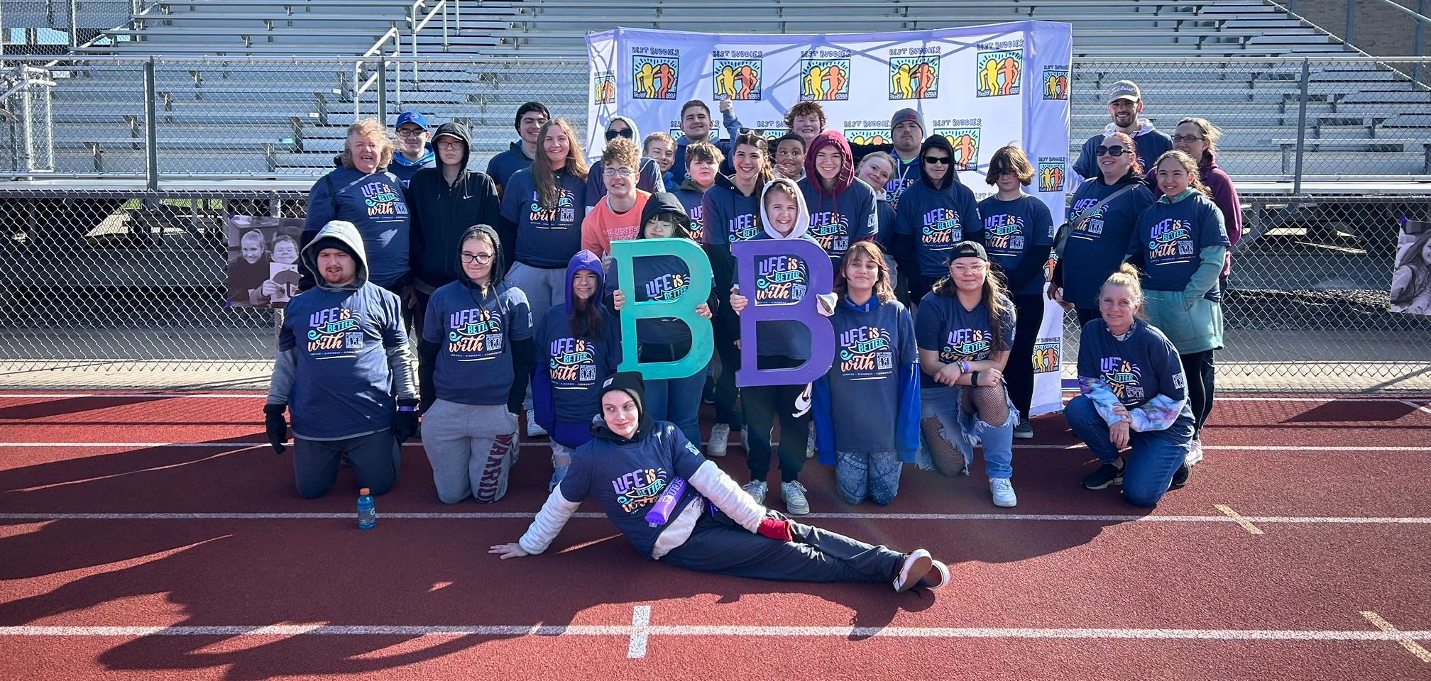 students posing on the track for the best buddies walk