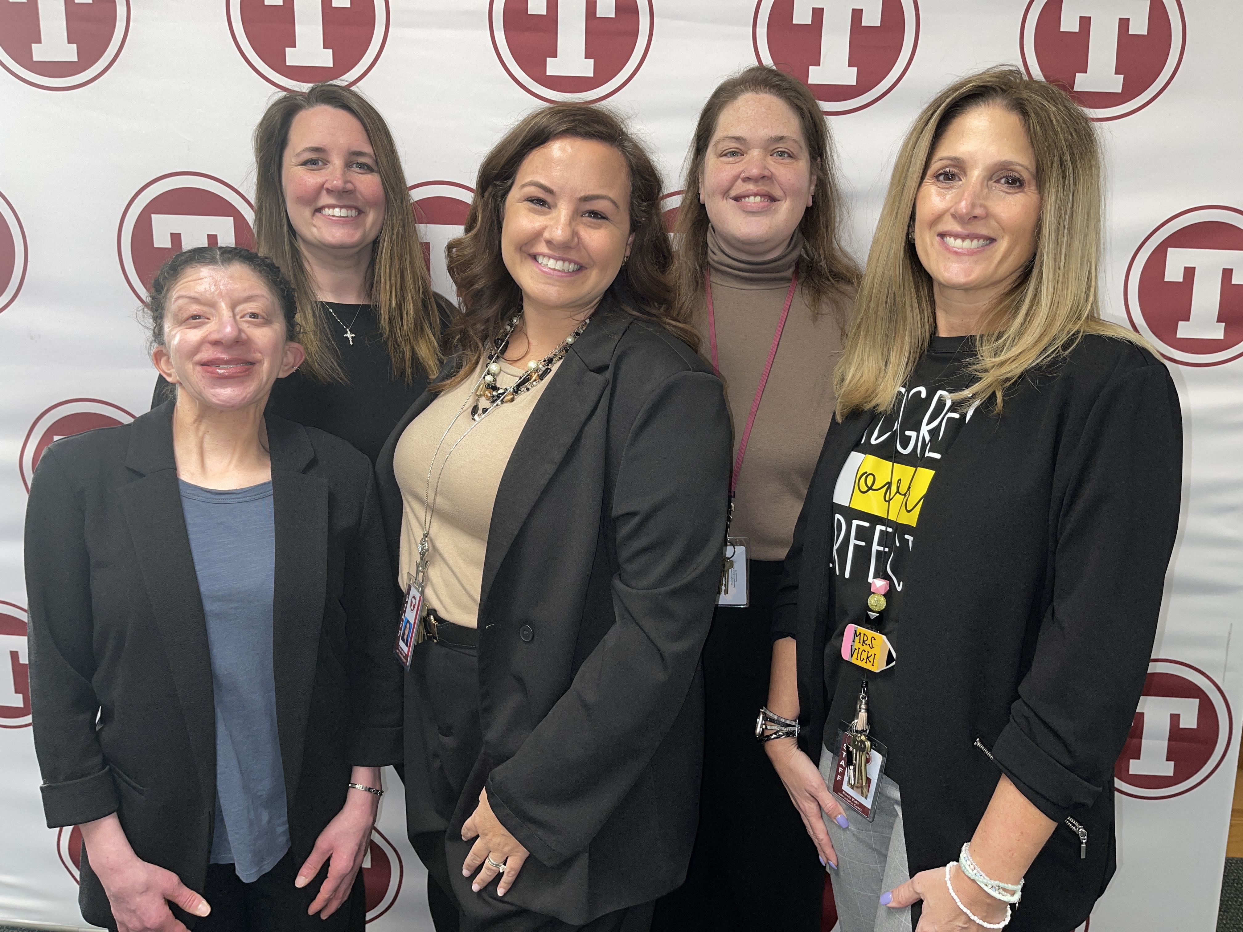 staff poses in front of tonawanda banner