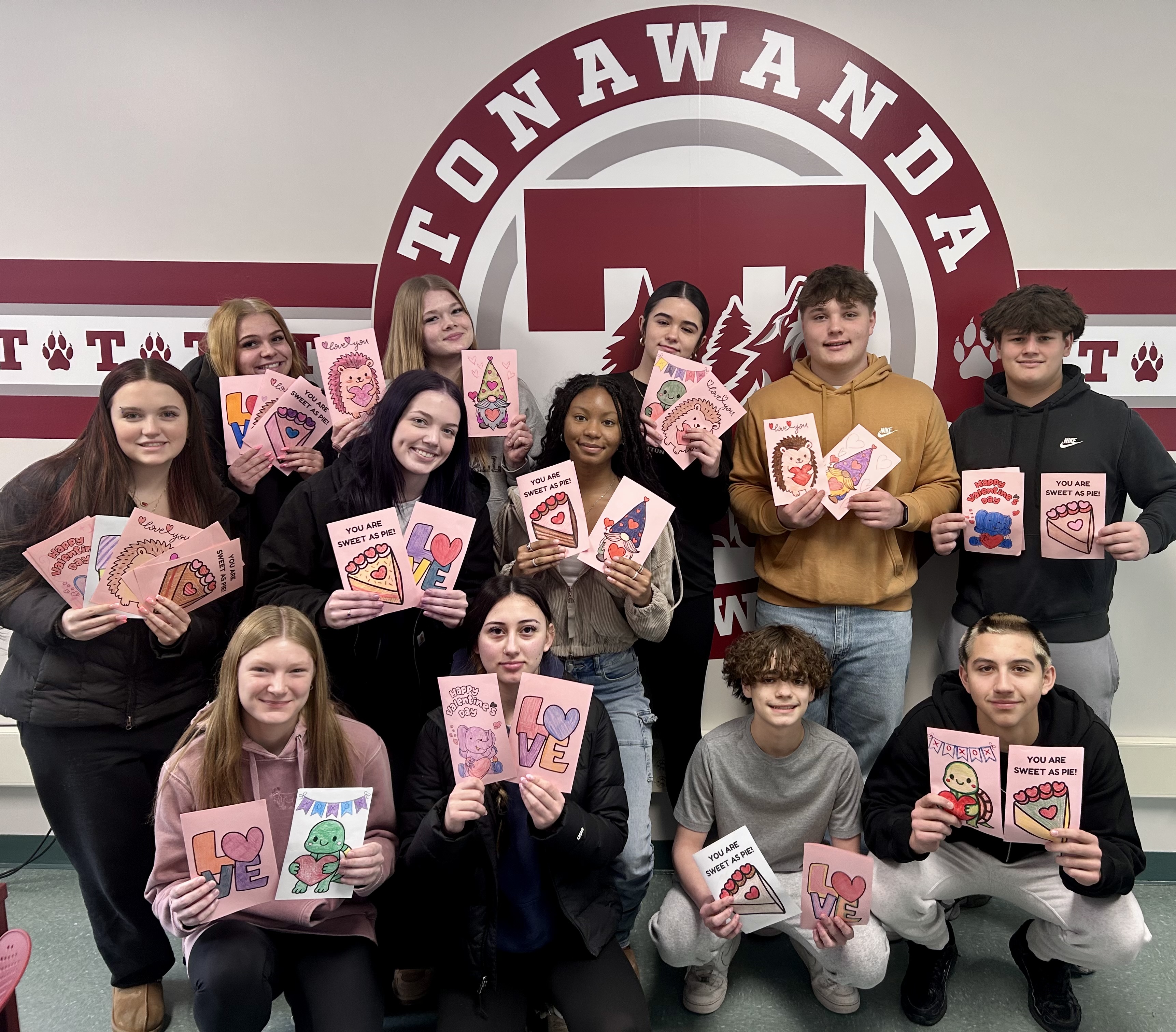 Students display valentines cards in front of Tonawanda logo