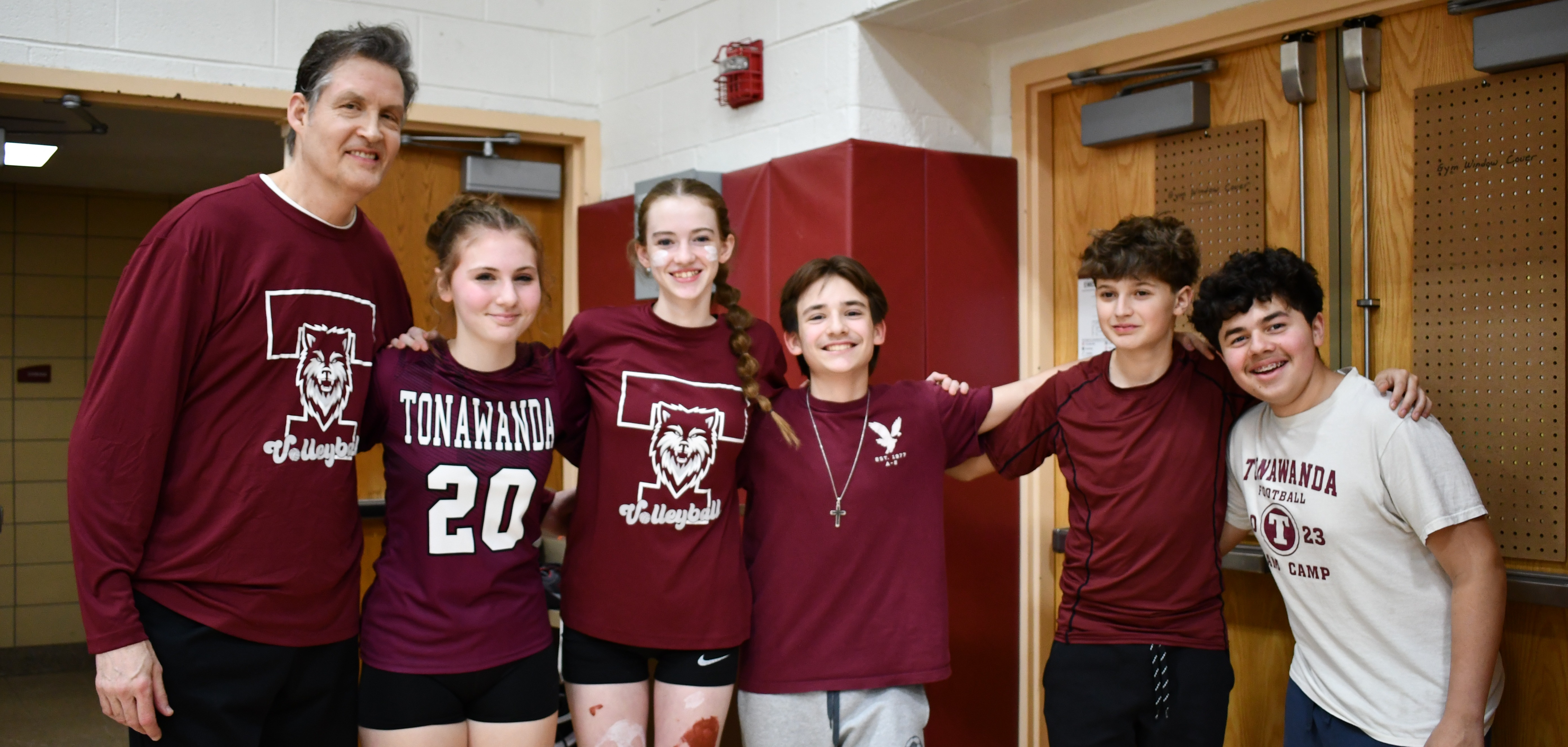 teacher and students pose in Tonawanda gear during volleyball tournament