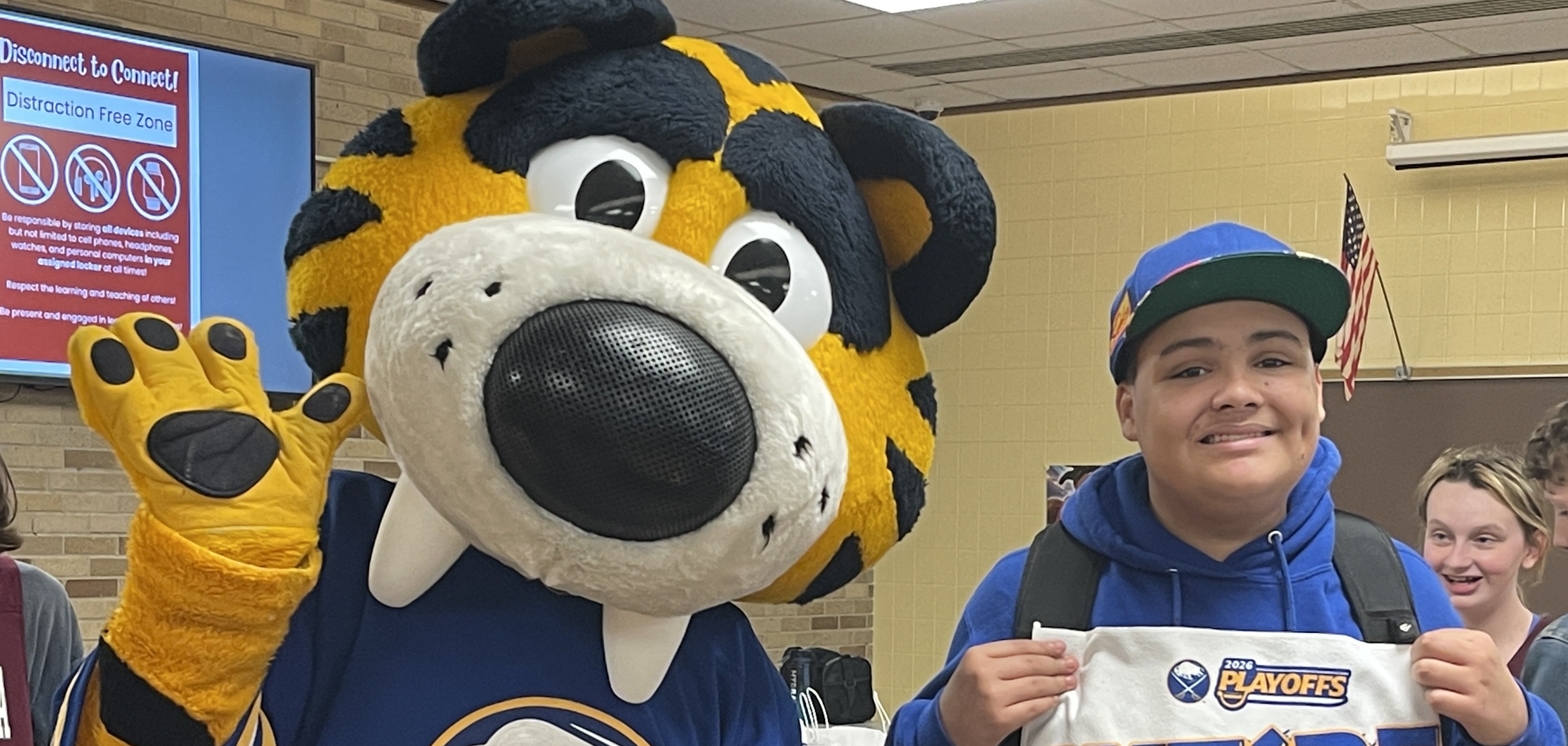 sabretooth poses with THS student holding We're Back sabres playoff towel