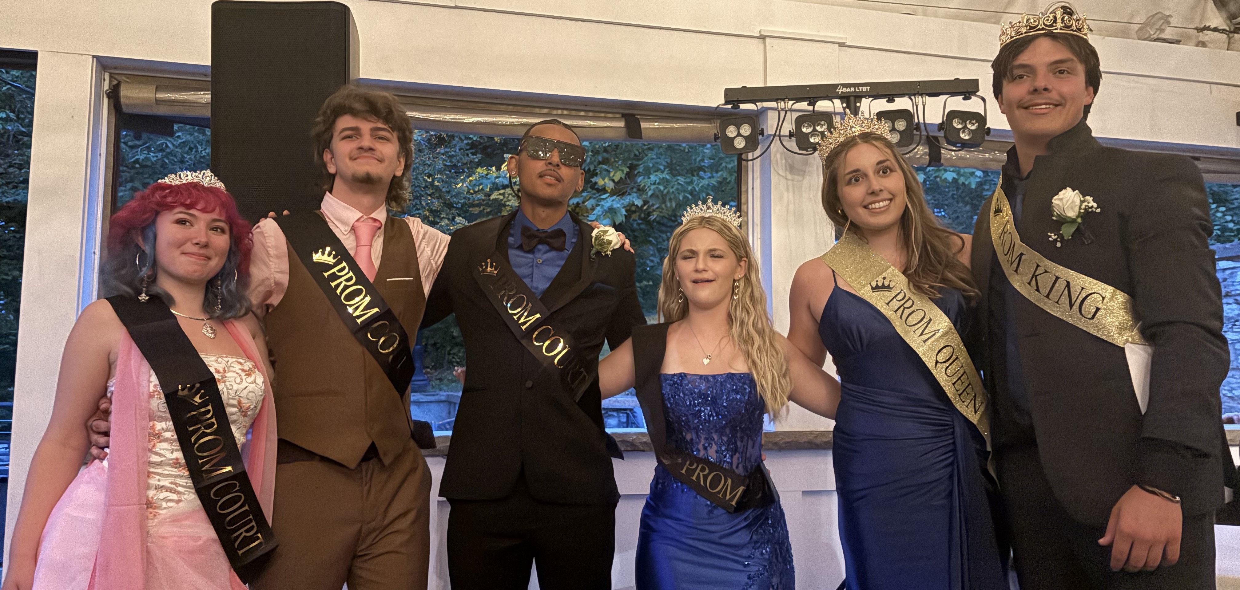 prom court poses at prom venue with crowns and sashes