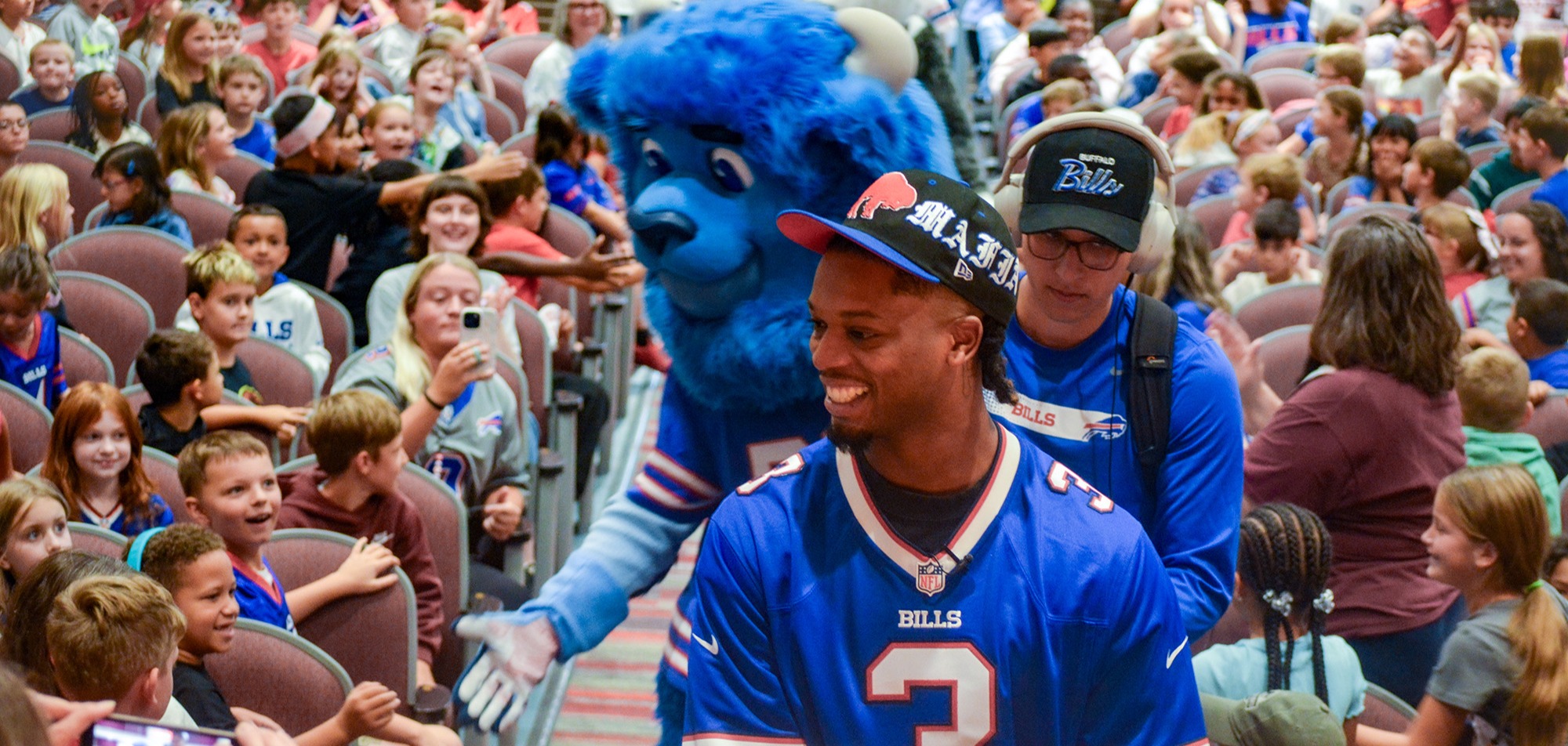 damar hamlin and billy buffalo coming down aisle of auditorium high fiving students