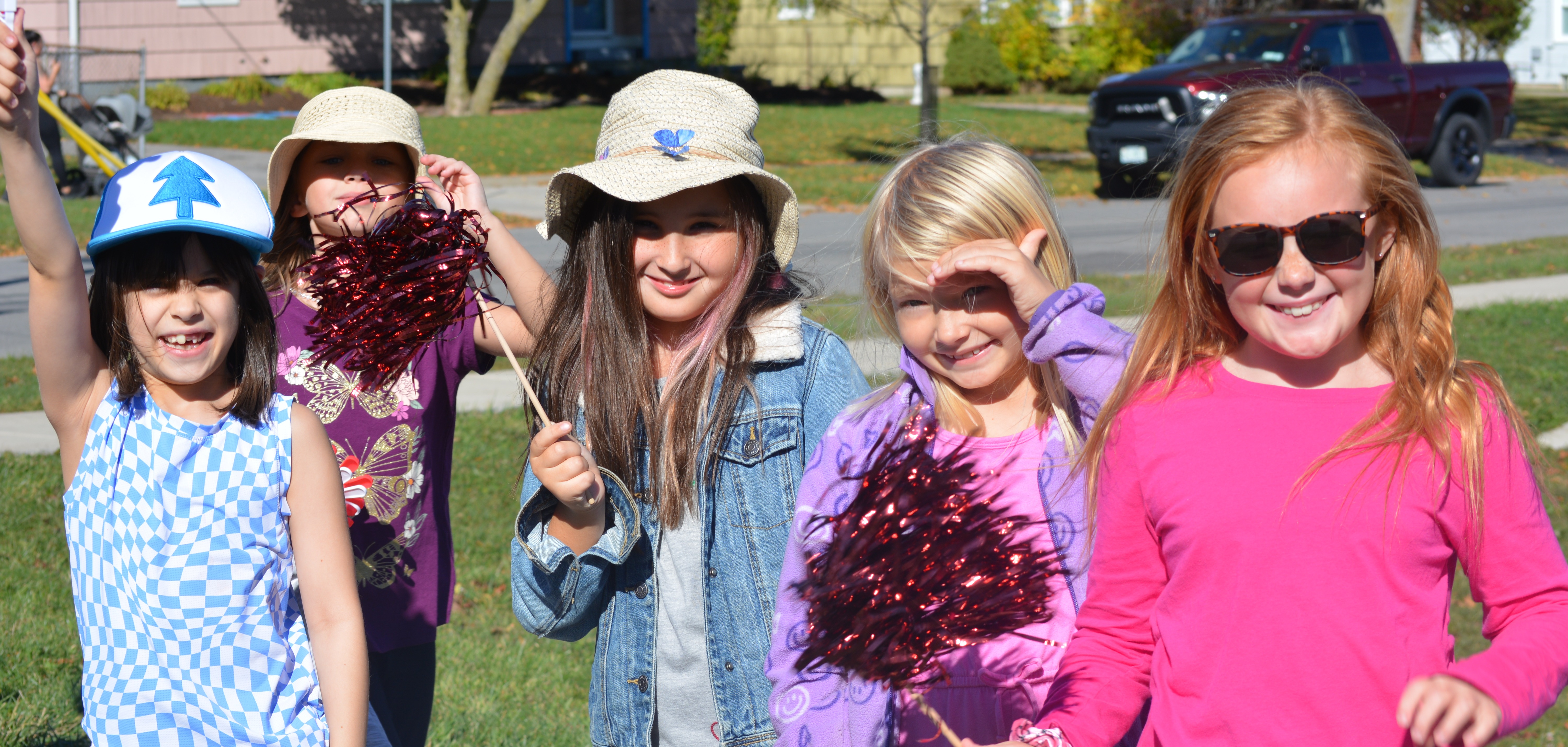children smile in a group outside school