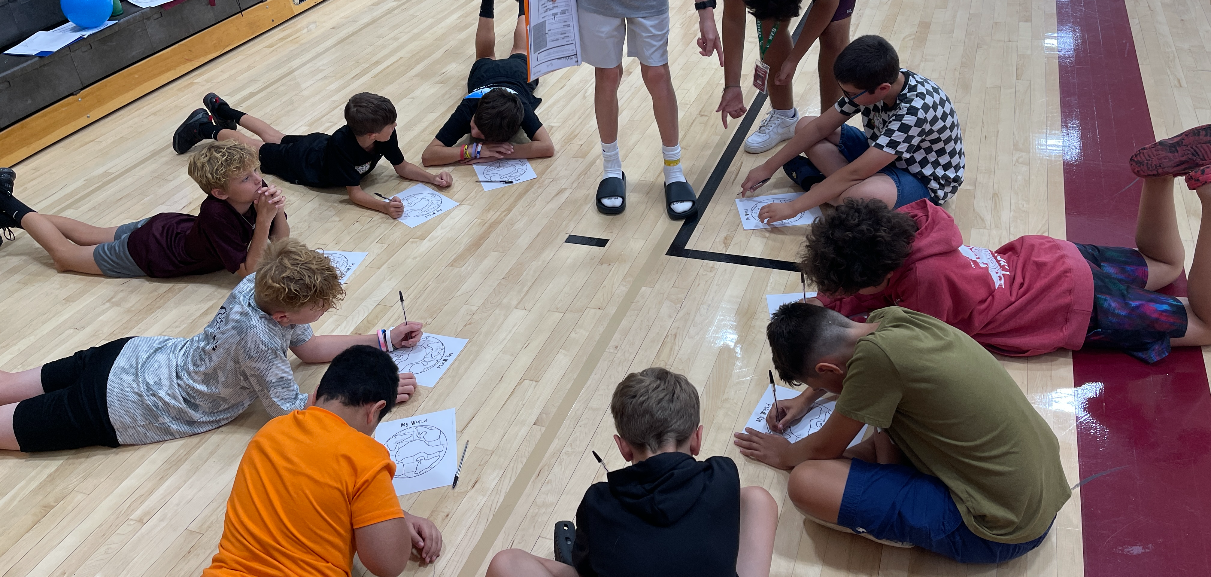 students working in a circle on a gym floor