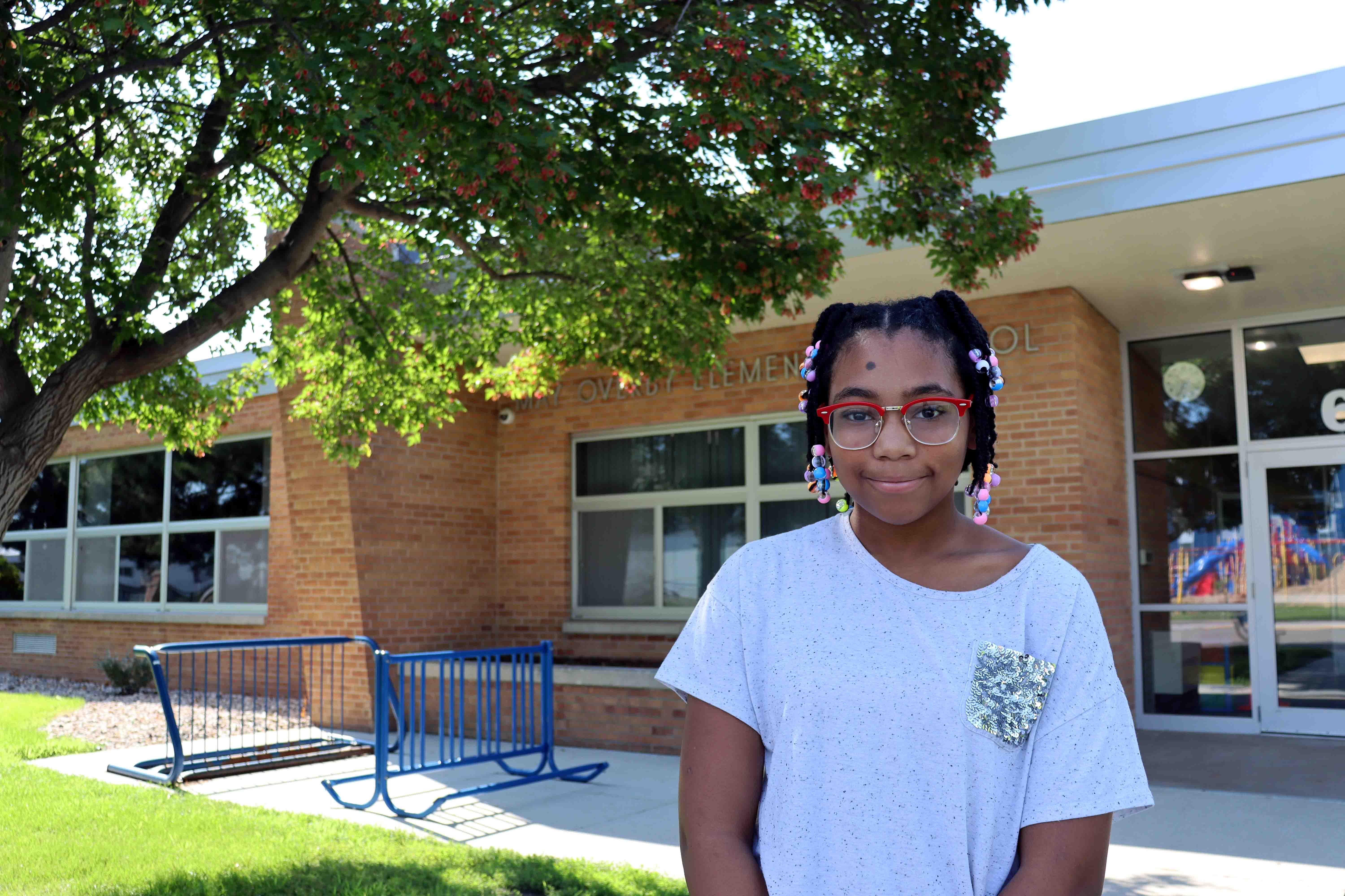 An elementary student standing outside of May Overby