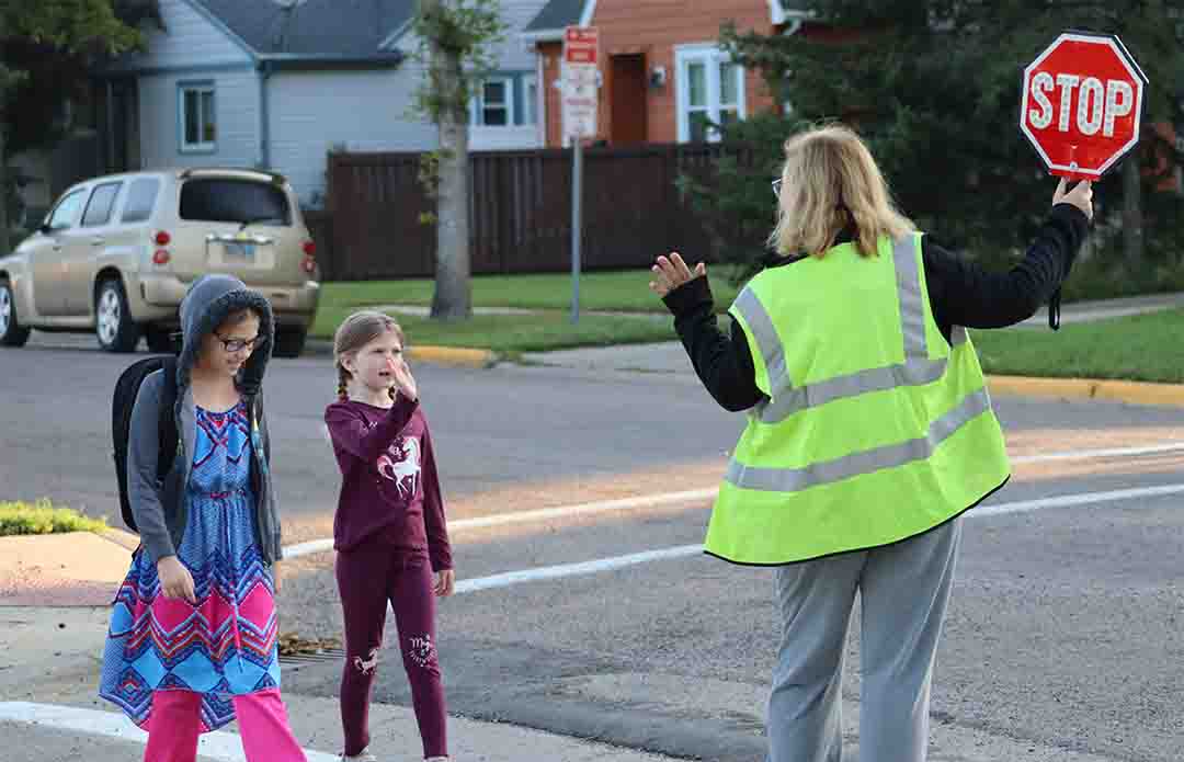 Students waving at a crossing guard