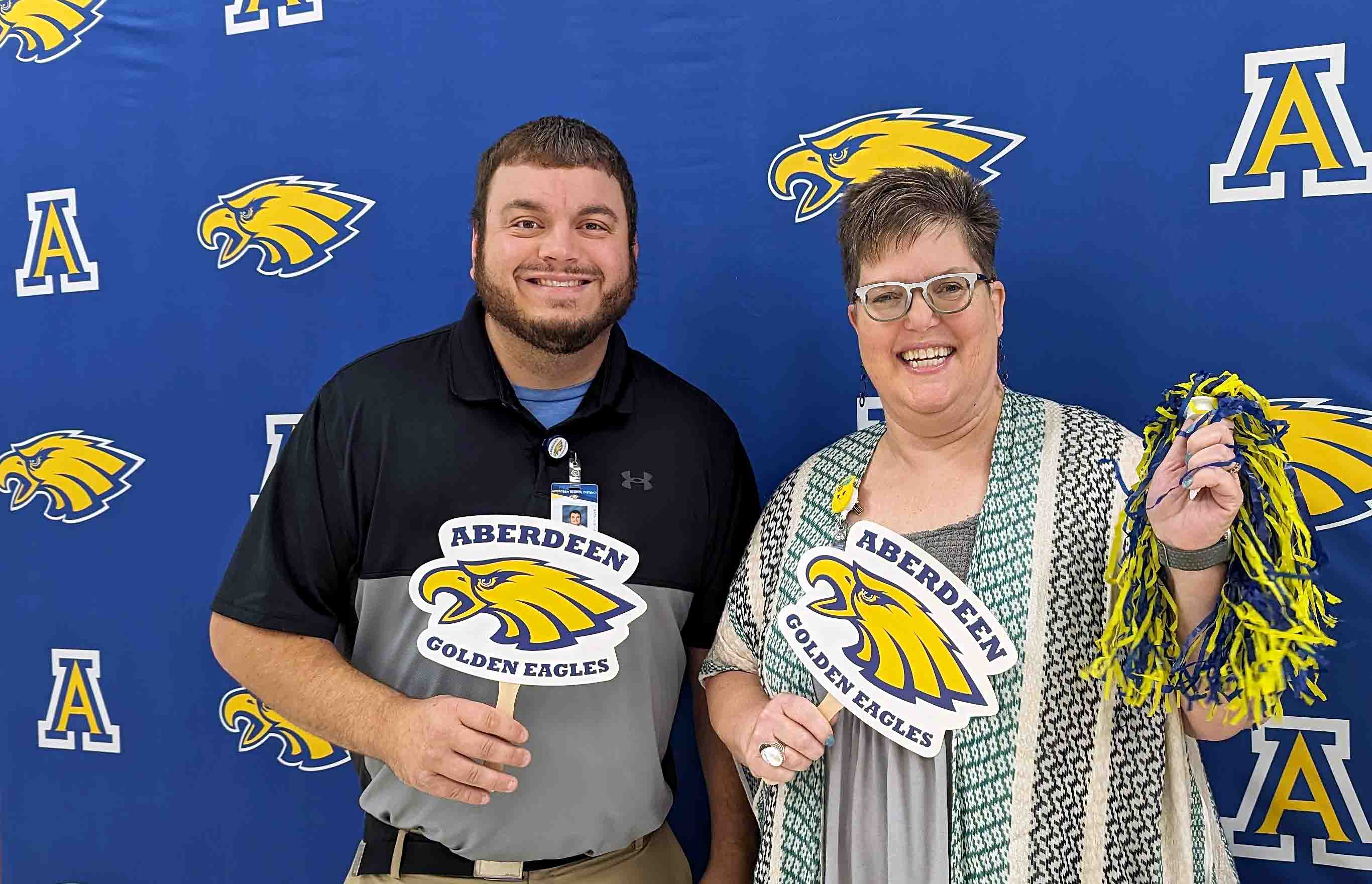 Two Aberdeen teachers in front of the school district backdrop