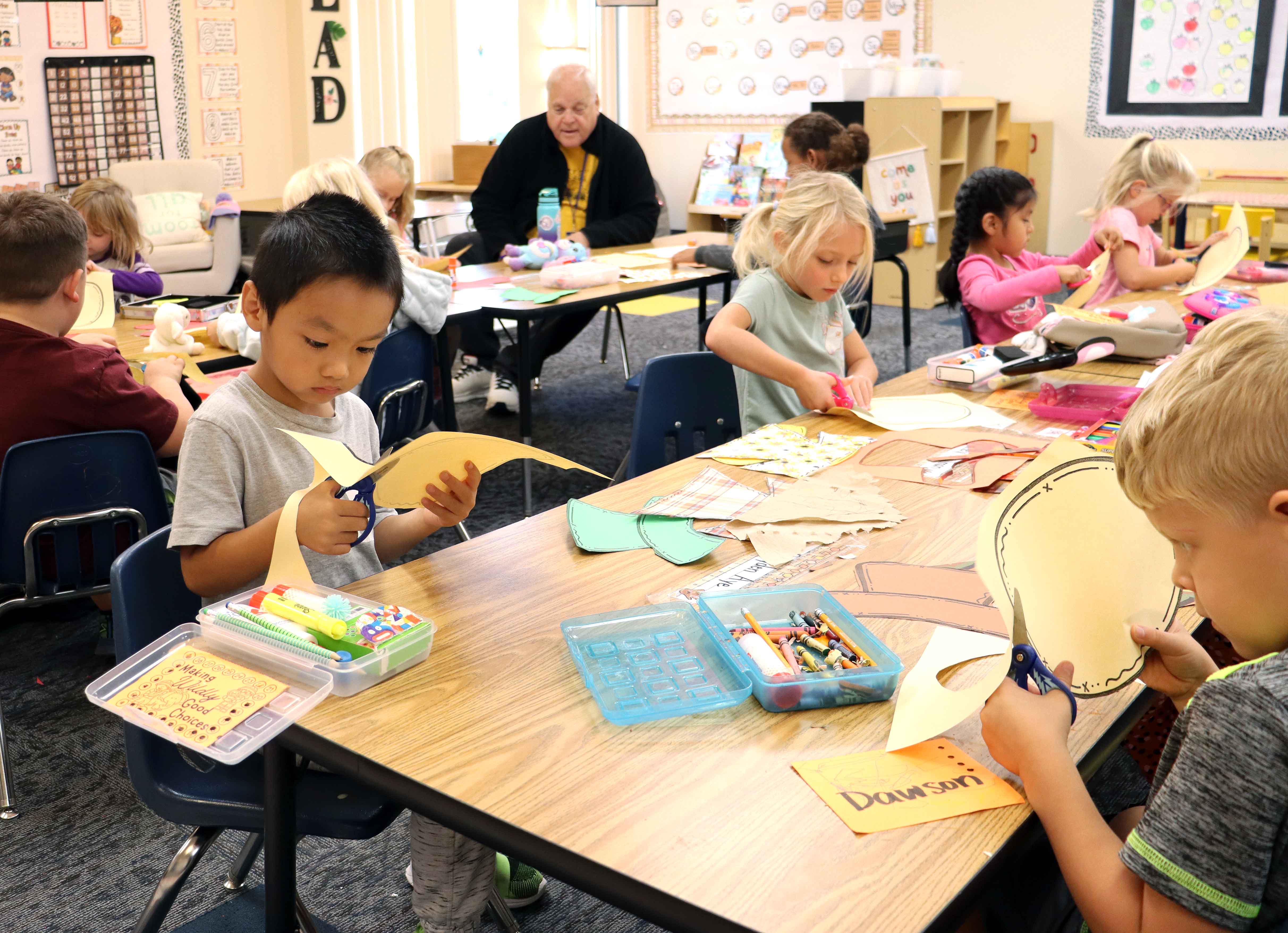 Elementary students cut paper during an art project