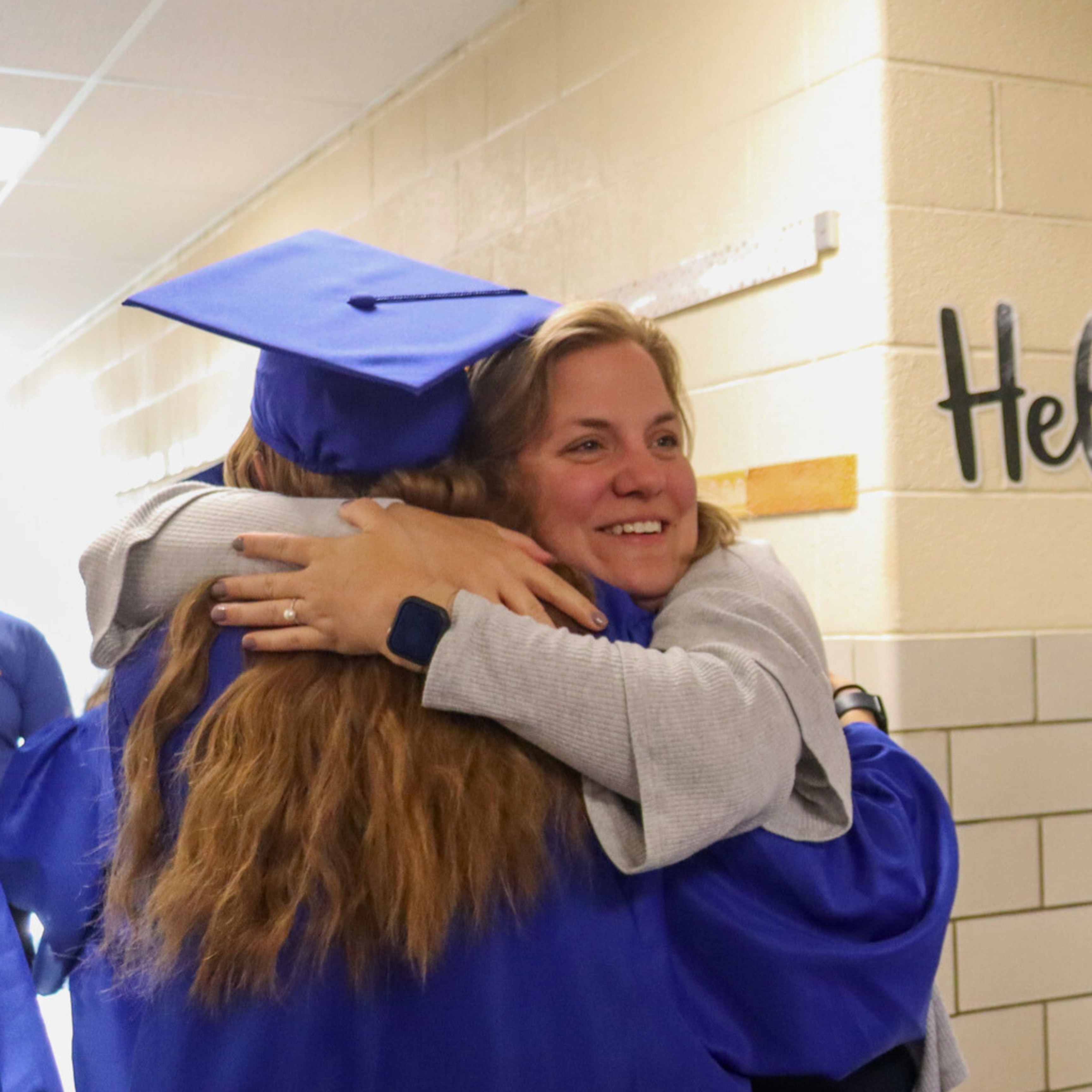 Teacher hugging graduate