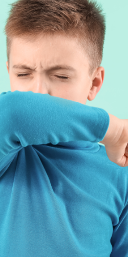 Boy covering his cough with elbow