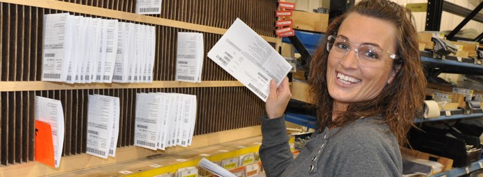 Female smiling at camera while filing papers away