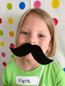 Little girl with paper moustache