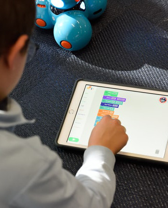 boy using block coding app on ipad