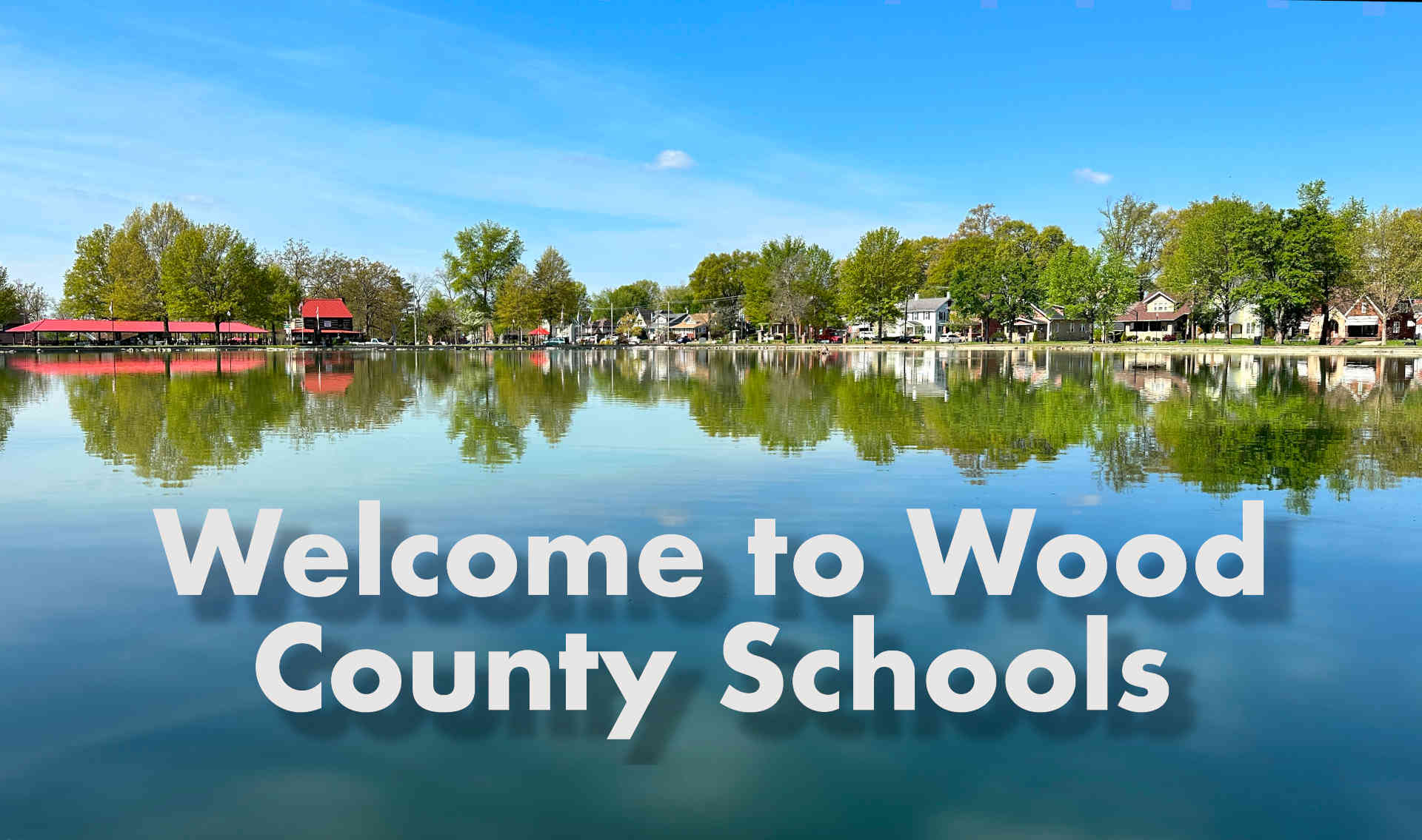 welcome to wood county schools image -- picture of city park with water in fore front and homes in the background