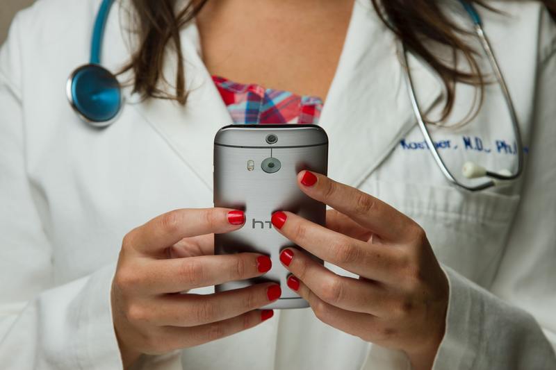 Photo of a doctor with a smarthphone.