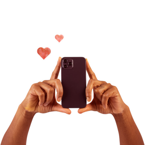 hands holding a black cell phone up as if recording something -- also, two redish pink hearts in the background