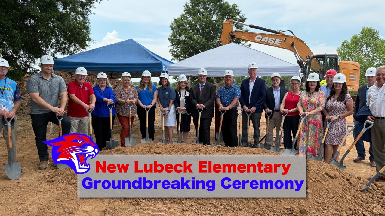 image of officials holding shovels and wearing hard hats for the groundbreaking of the new lubeck elementary school