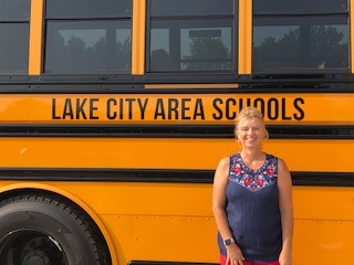 Woman in front of school bus