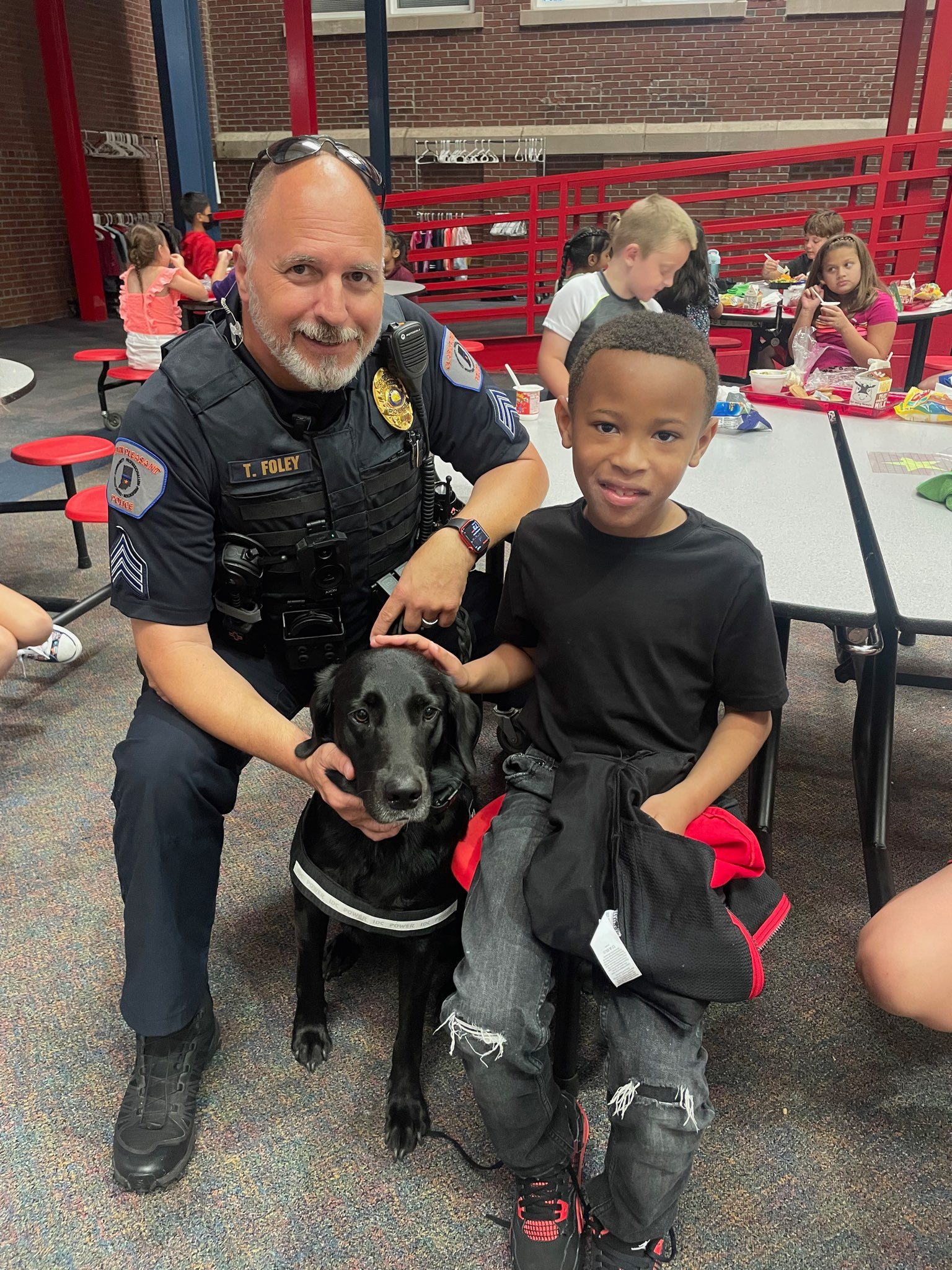 Sergeant Foley and K9 Sally eating lunch with a student