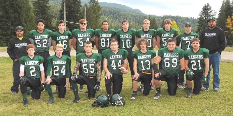 Football team picture on field with mountains in background