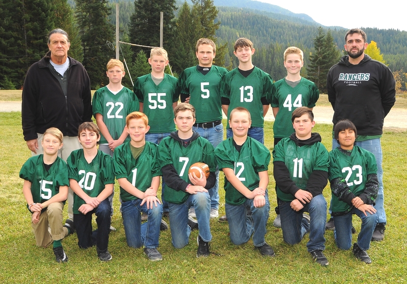 Football team picture on field with mountains in background