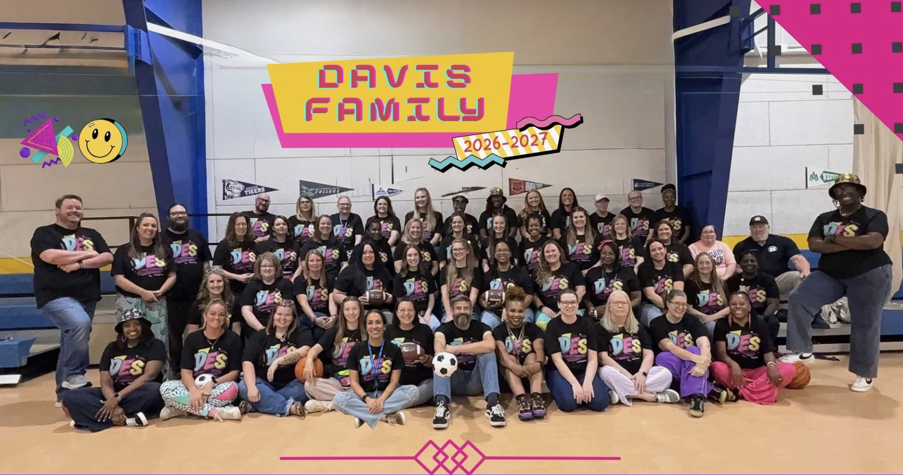 A large group of people in matching shirts pose for a photo in a gymnasium.
