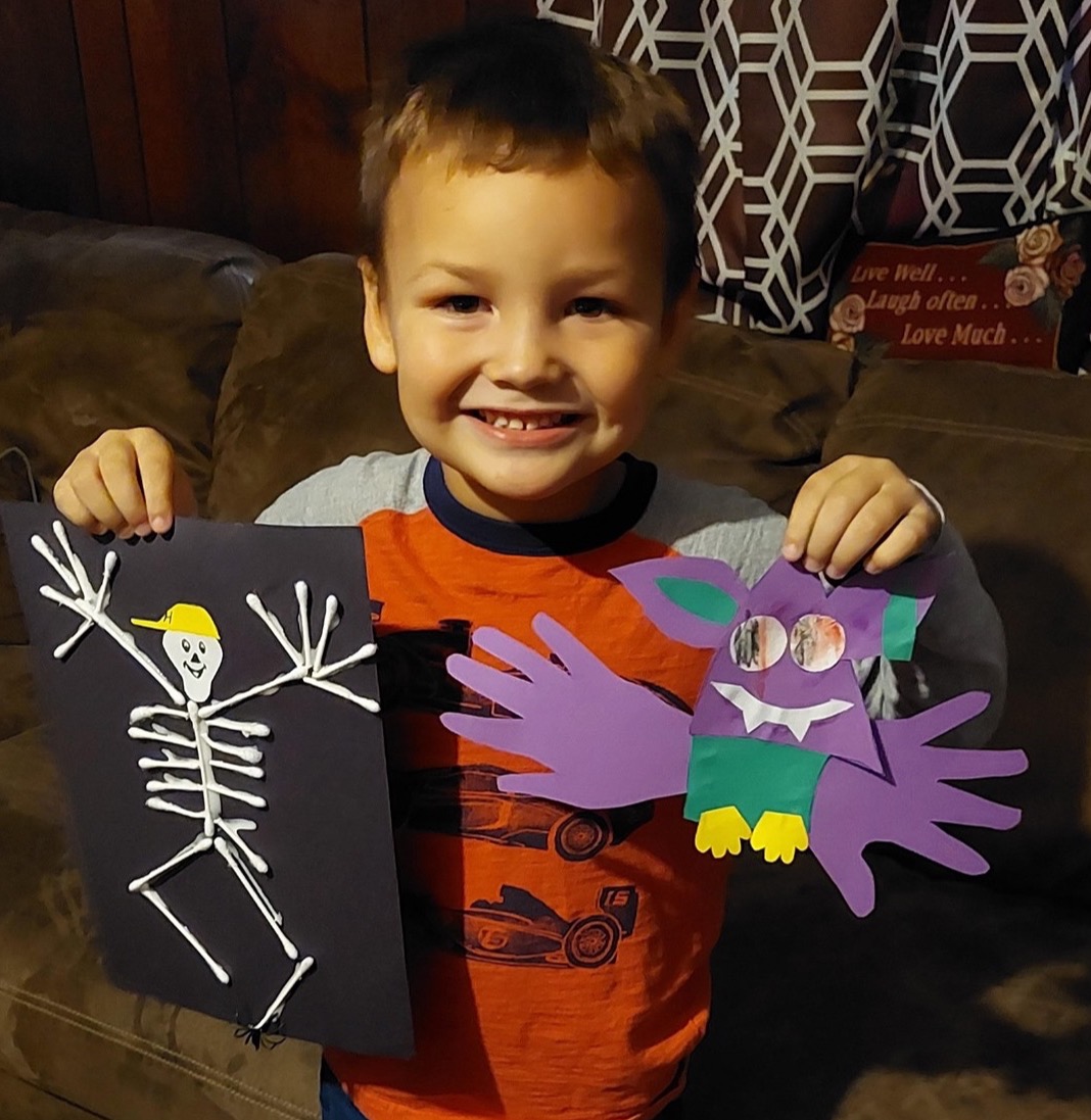 Child holding his PAT crafts