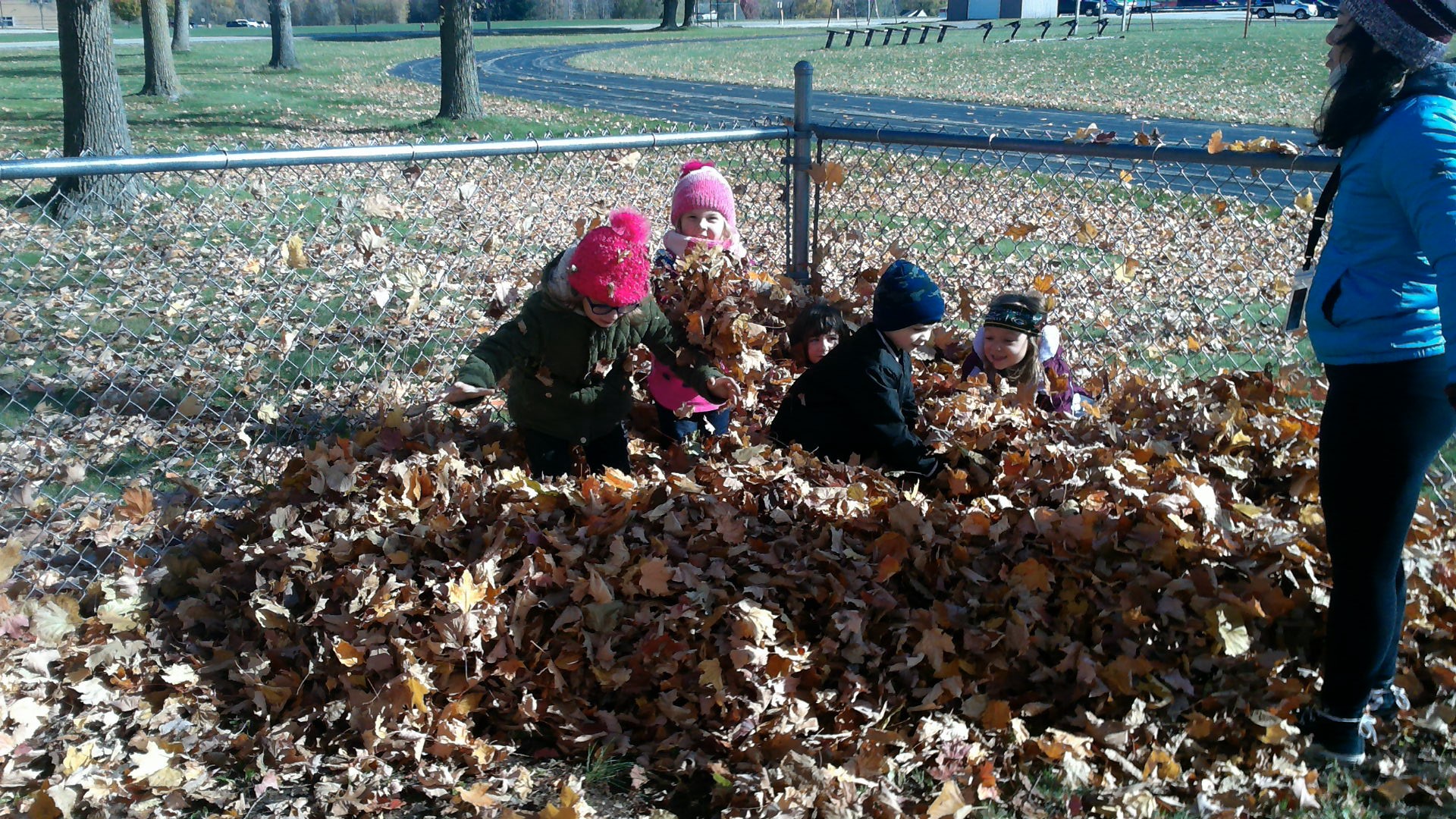 STUDENTS PLAYING WITH THE LEAVES.