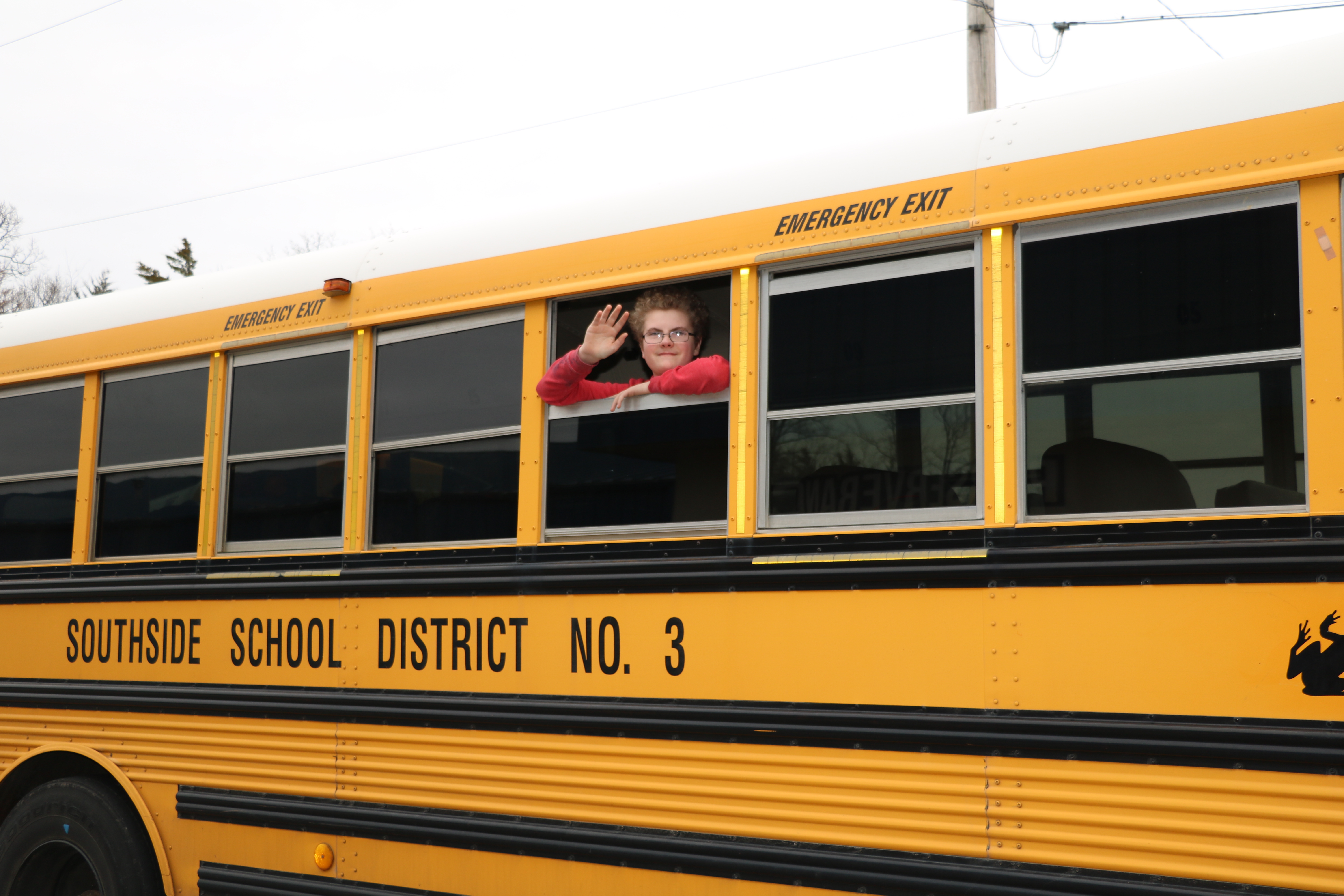 Student waving from school bus
