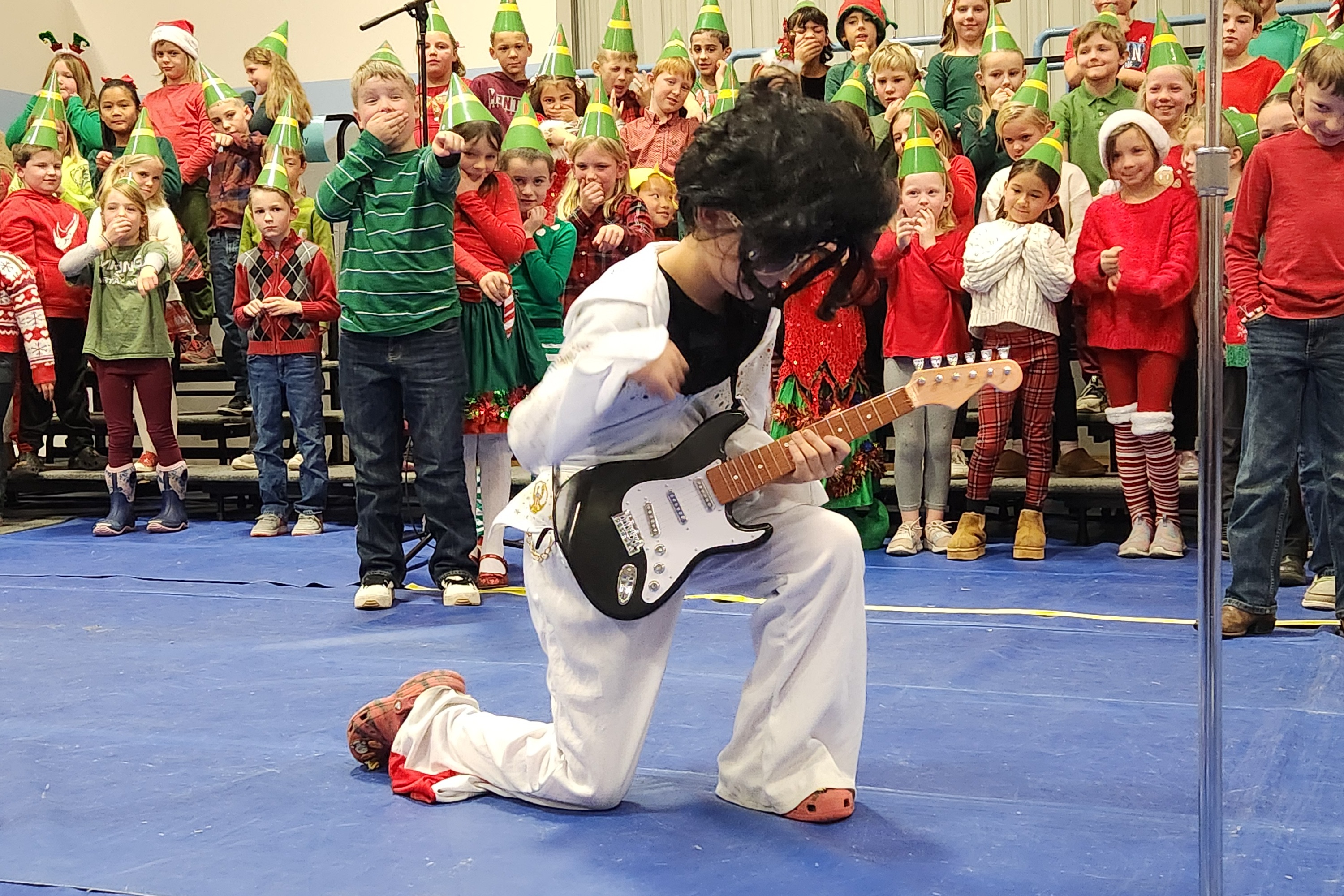 a 3rd grader poses playing his guitar