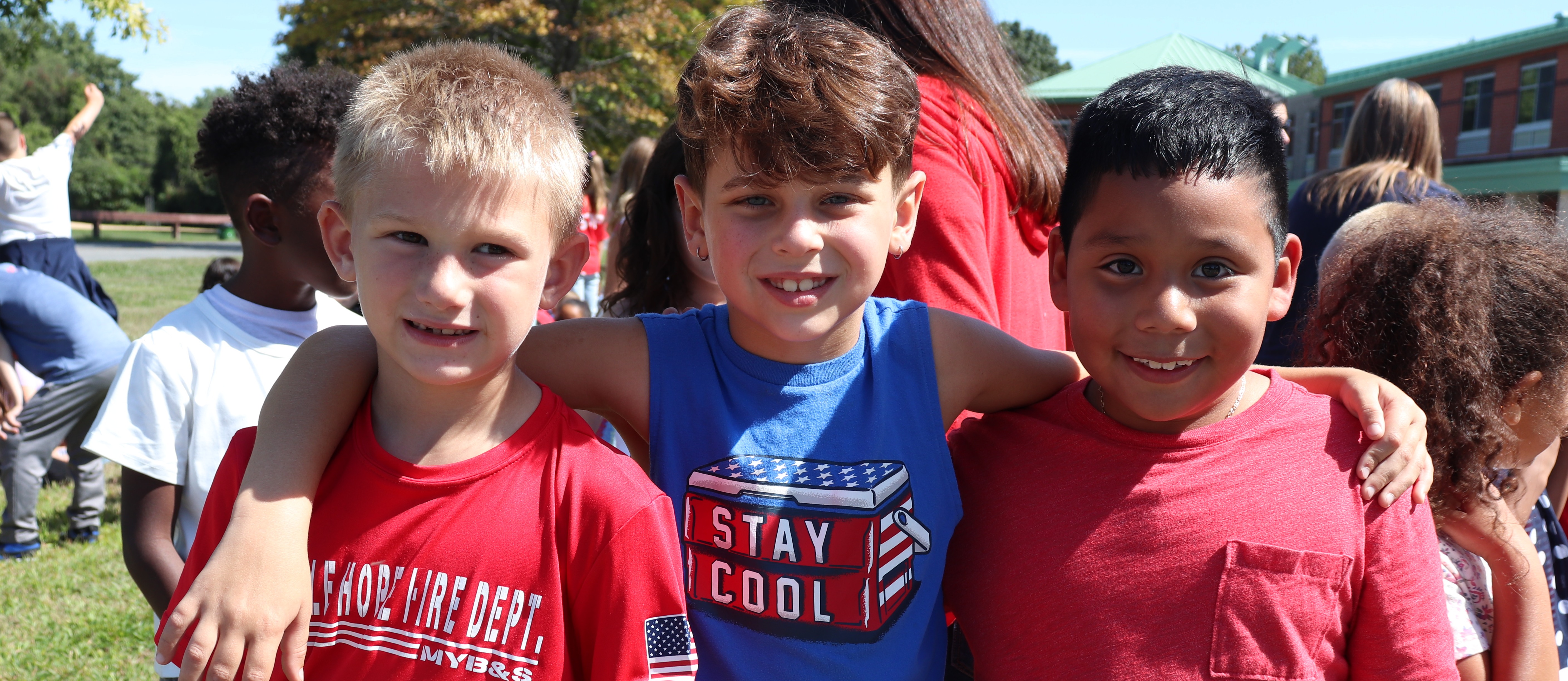 Three students smile at the camera